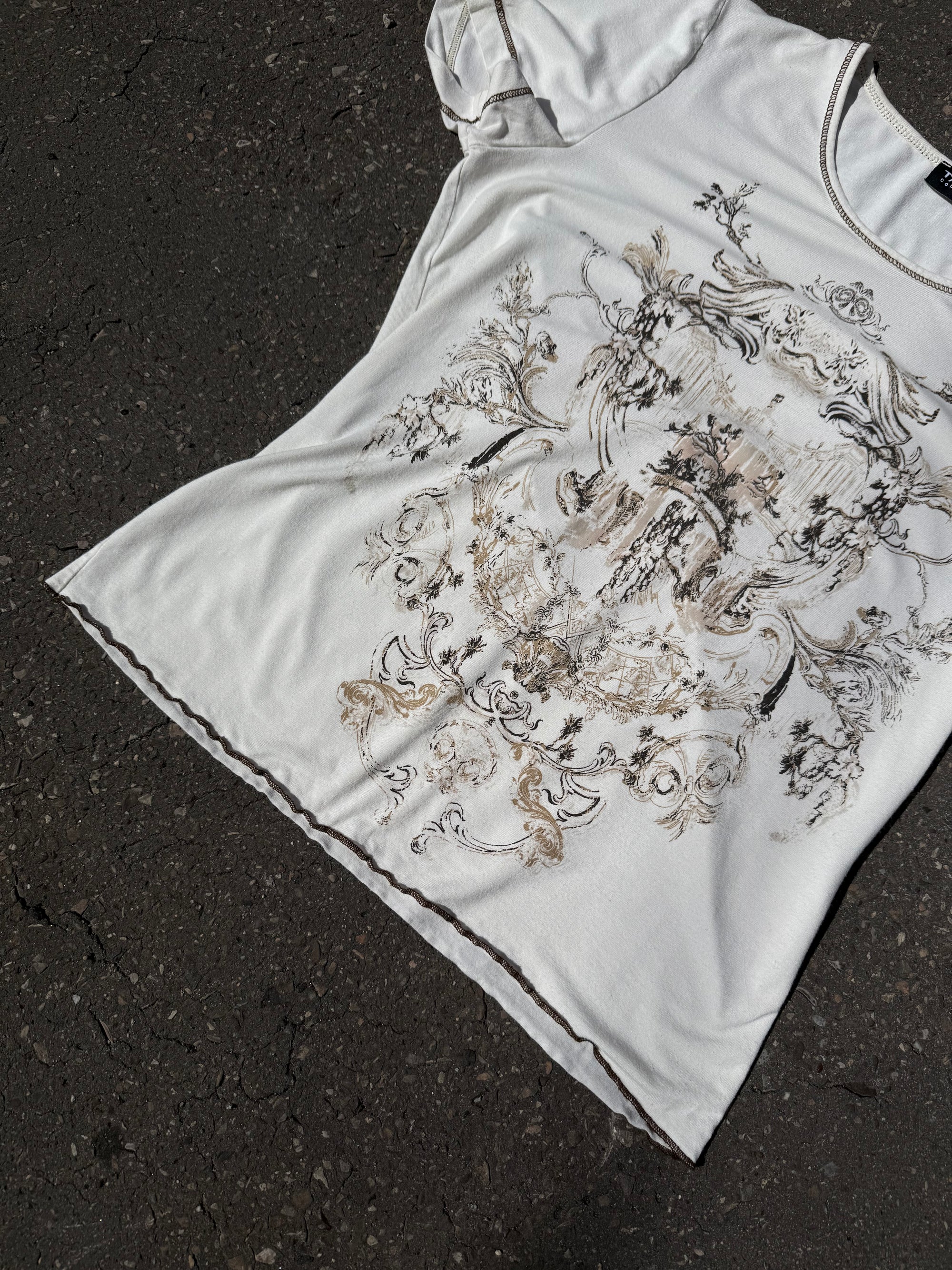 Weißes tshirt mit beige braunem Schnörkel Print auf der Vorderseite 