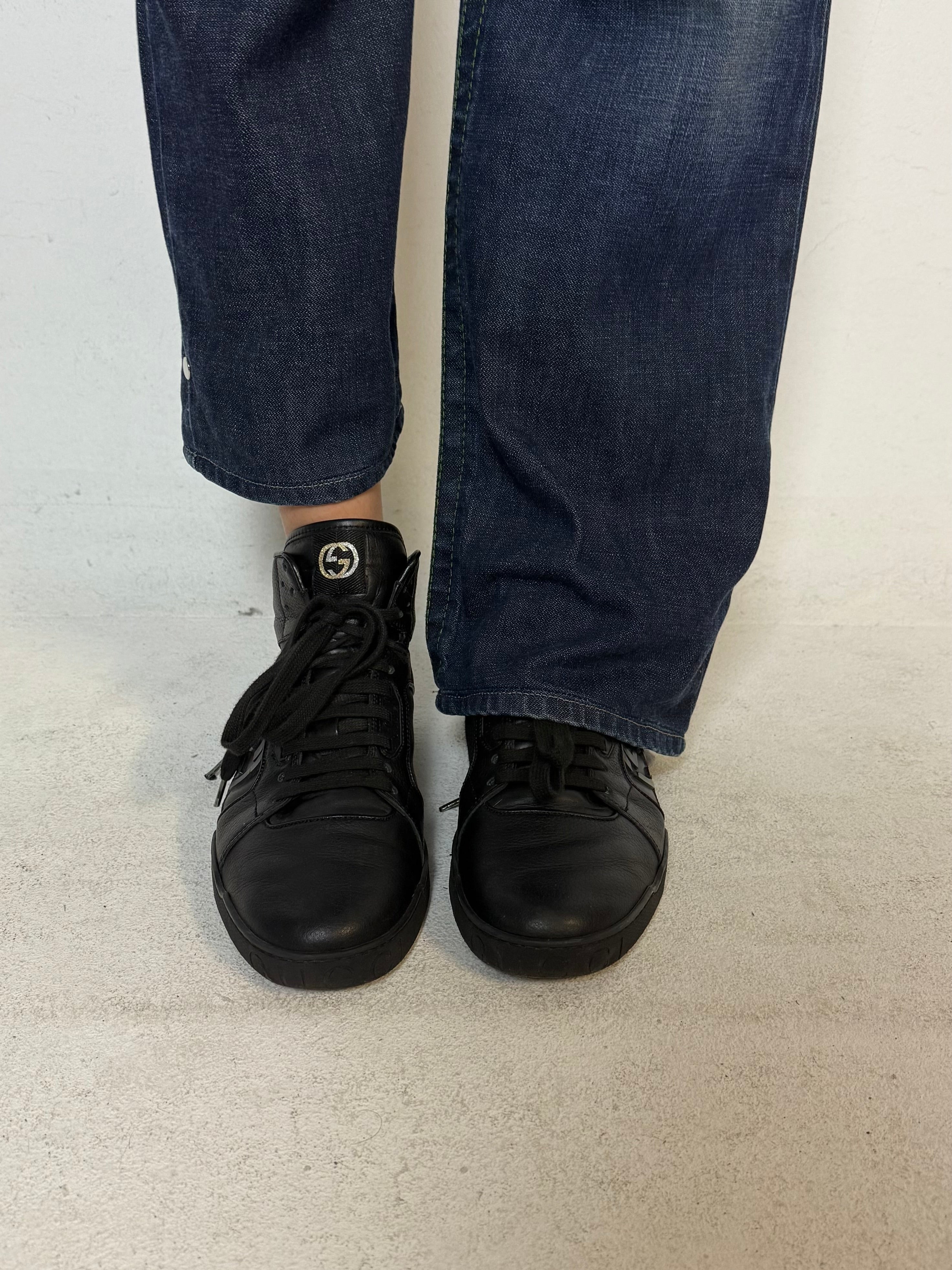 Schwarze gucci sneaker mit roten details hinten und roter sohle 