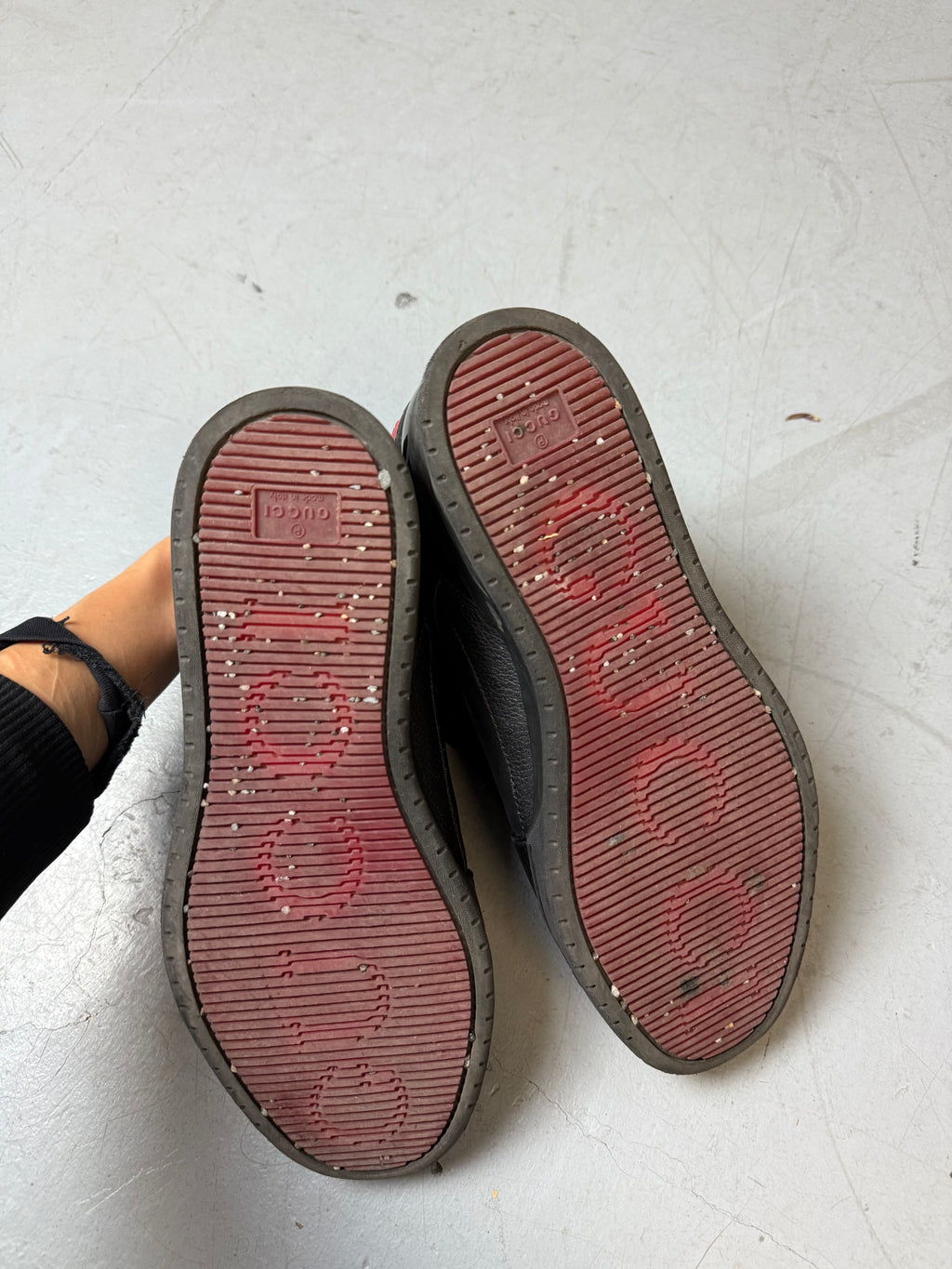 Schwarze gucci sneaker mit roten details hinten und roter sohle 