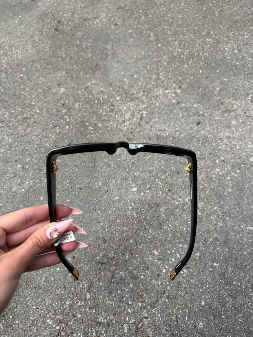 Eine schwarze Sonnenbrille von Jacquemus mit goldenem Schriftzug auf der Seite