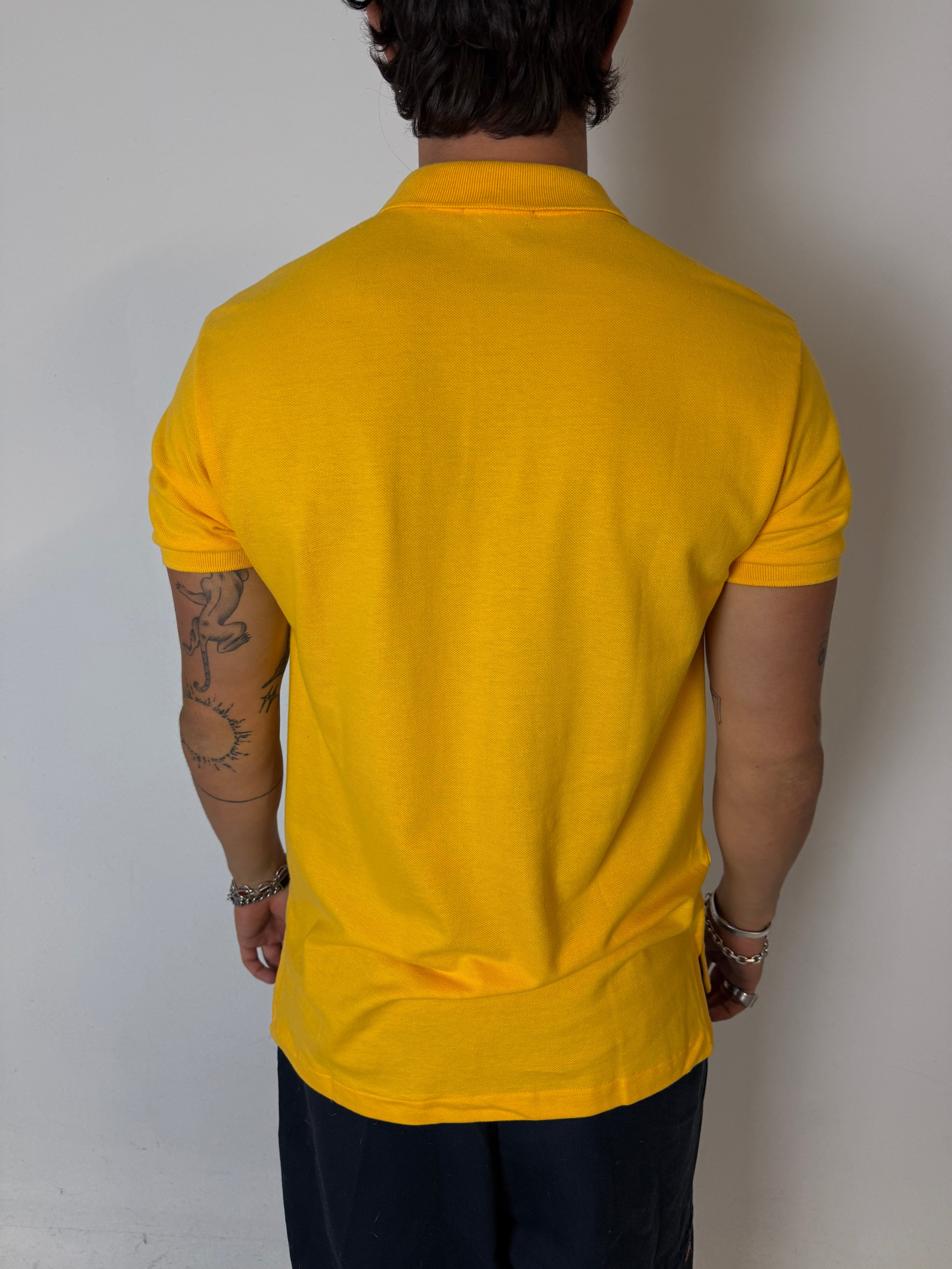 Ein gelbes Polo von Ralph Lauren mit blauem Reiter auf der Brust in L