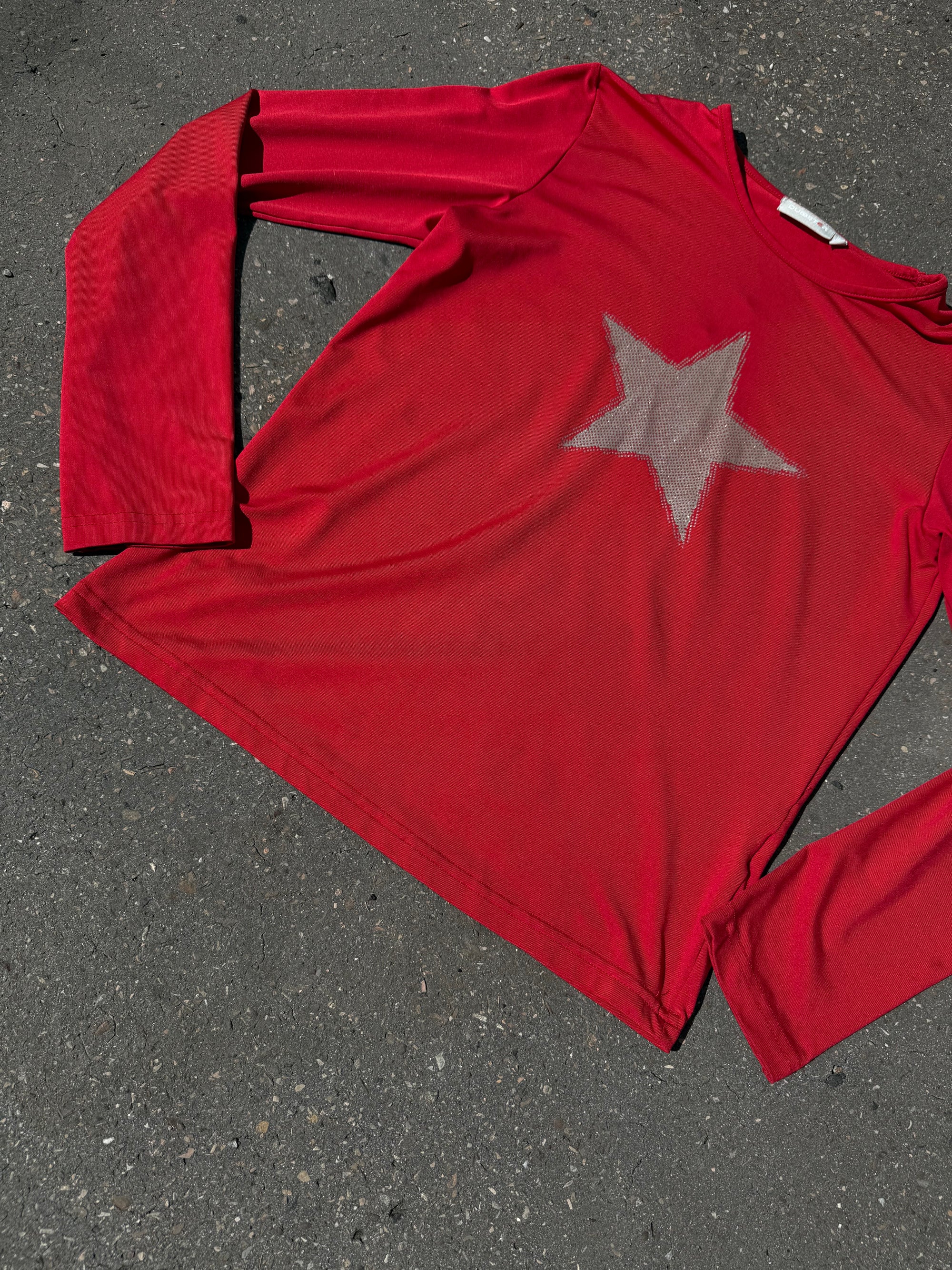 Ein rotes longsleeve mit einem Stern in der Mitte 