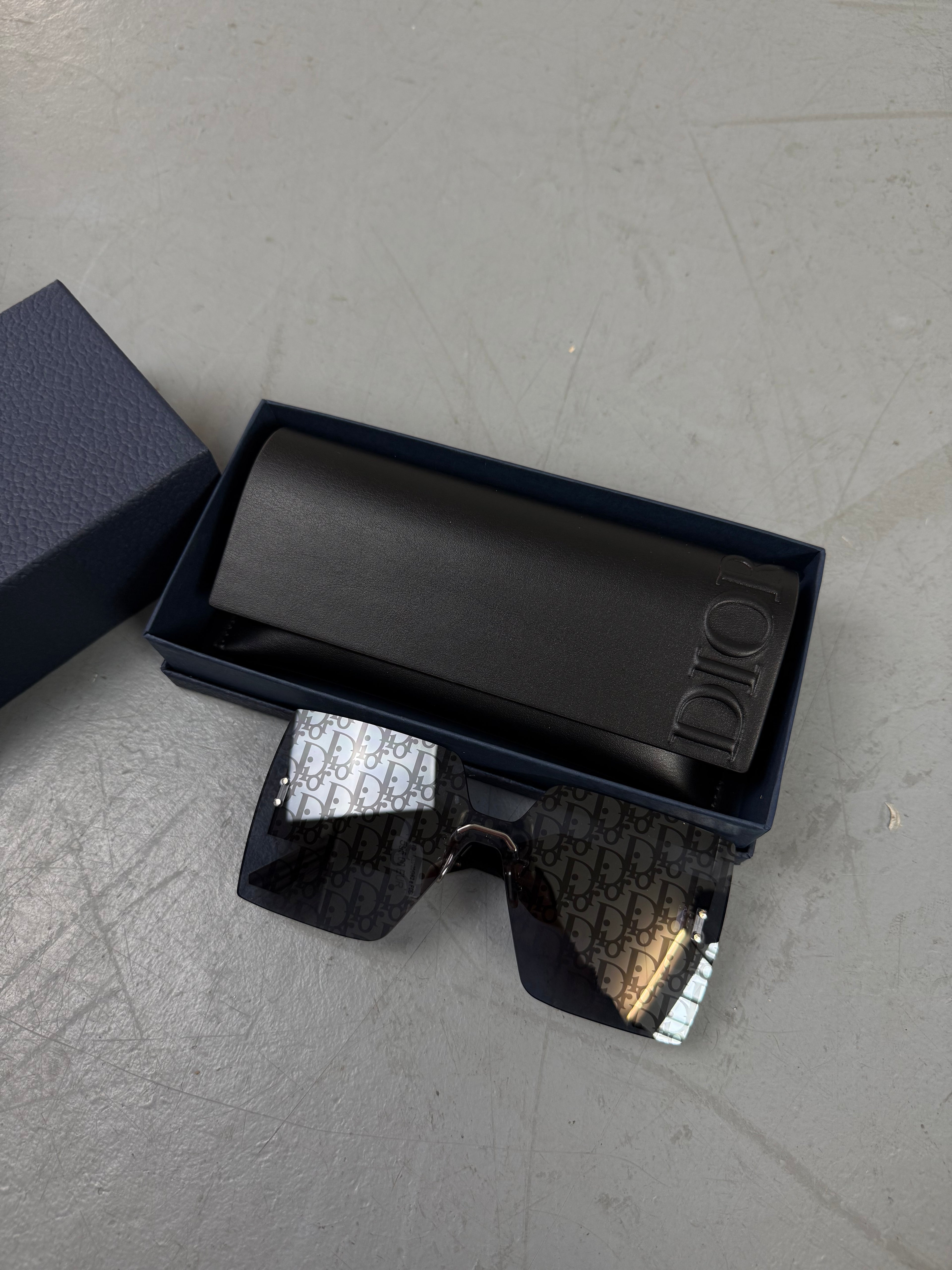 Eine neue Sonnenbrille von dir mit großen eckigen Gläsern mit dem Dior monogram drauf 