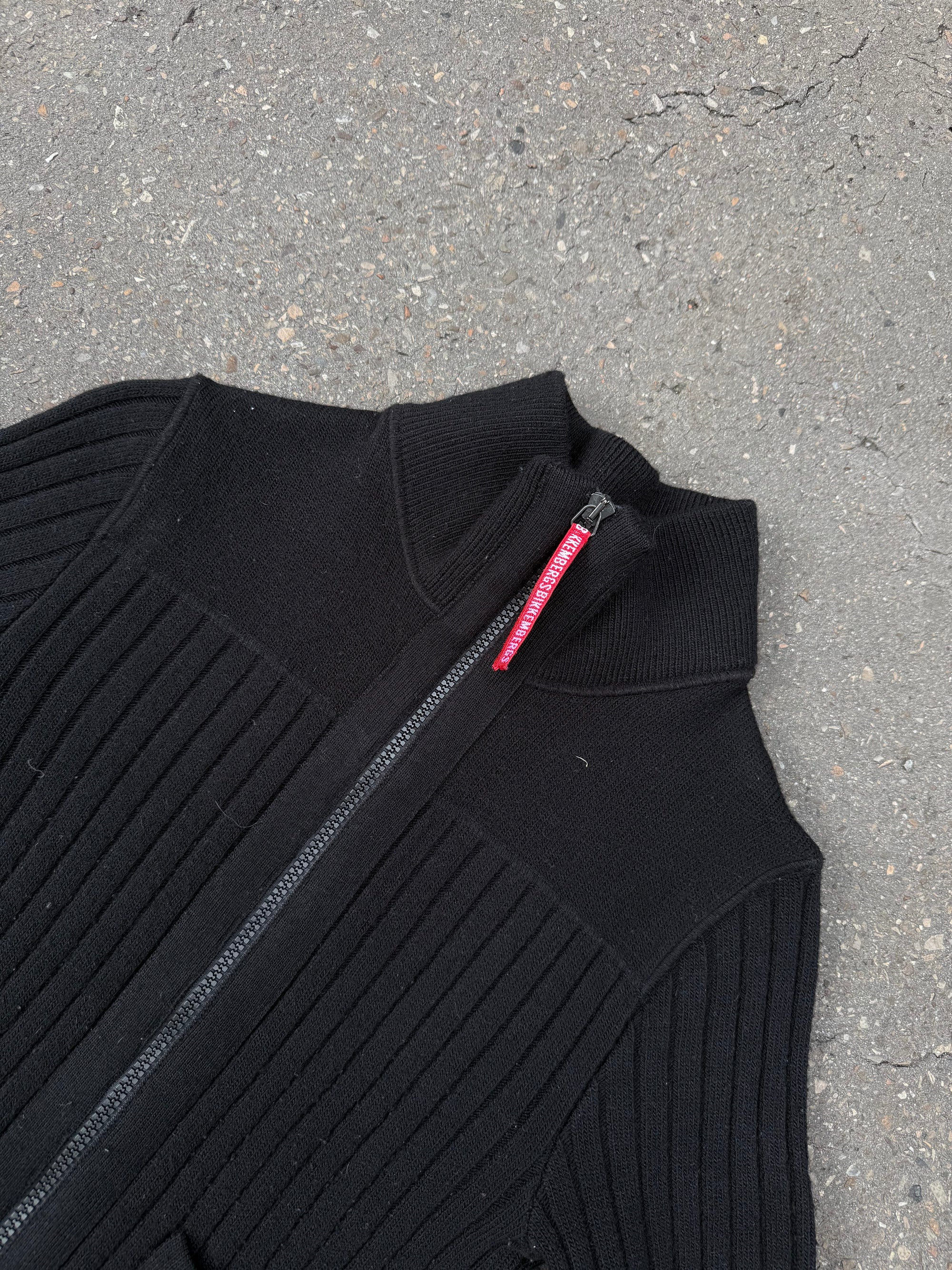 Ein schwarzer Strick Zipper von Dirk Bikkembergs mit roter Schlaufe am Reißverschluss in XS