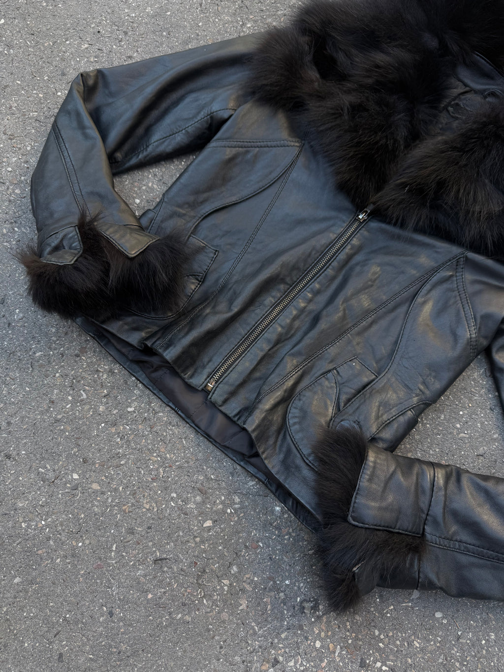 Eine schwarze Lederjacke mit Faux Fur am Kragen und an den Ärmeln