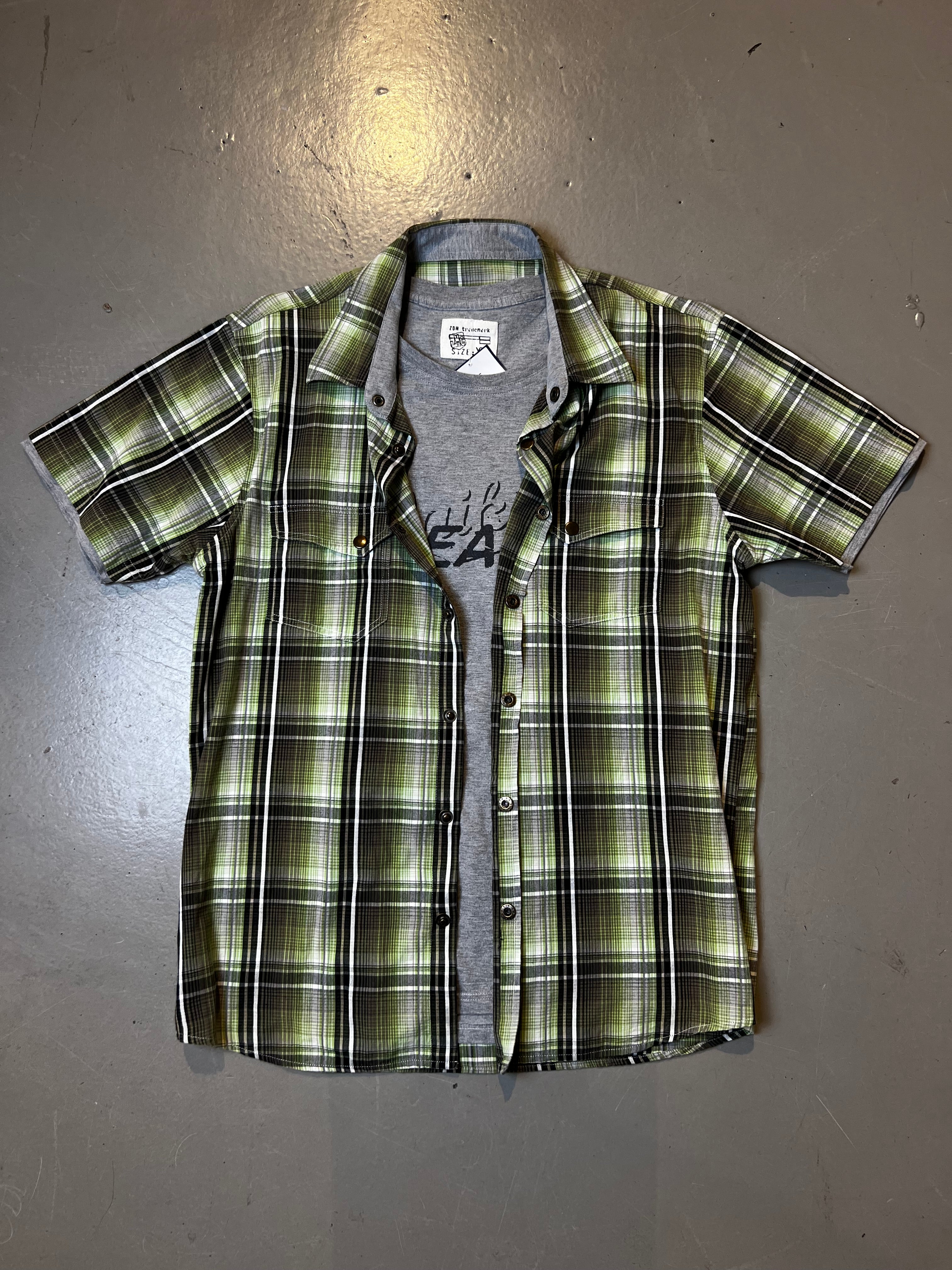 Ein Grün kariertes kurzärmliges Hemd mit einem grauen T-Shirt darunter in XL