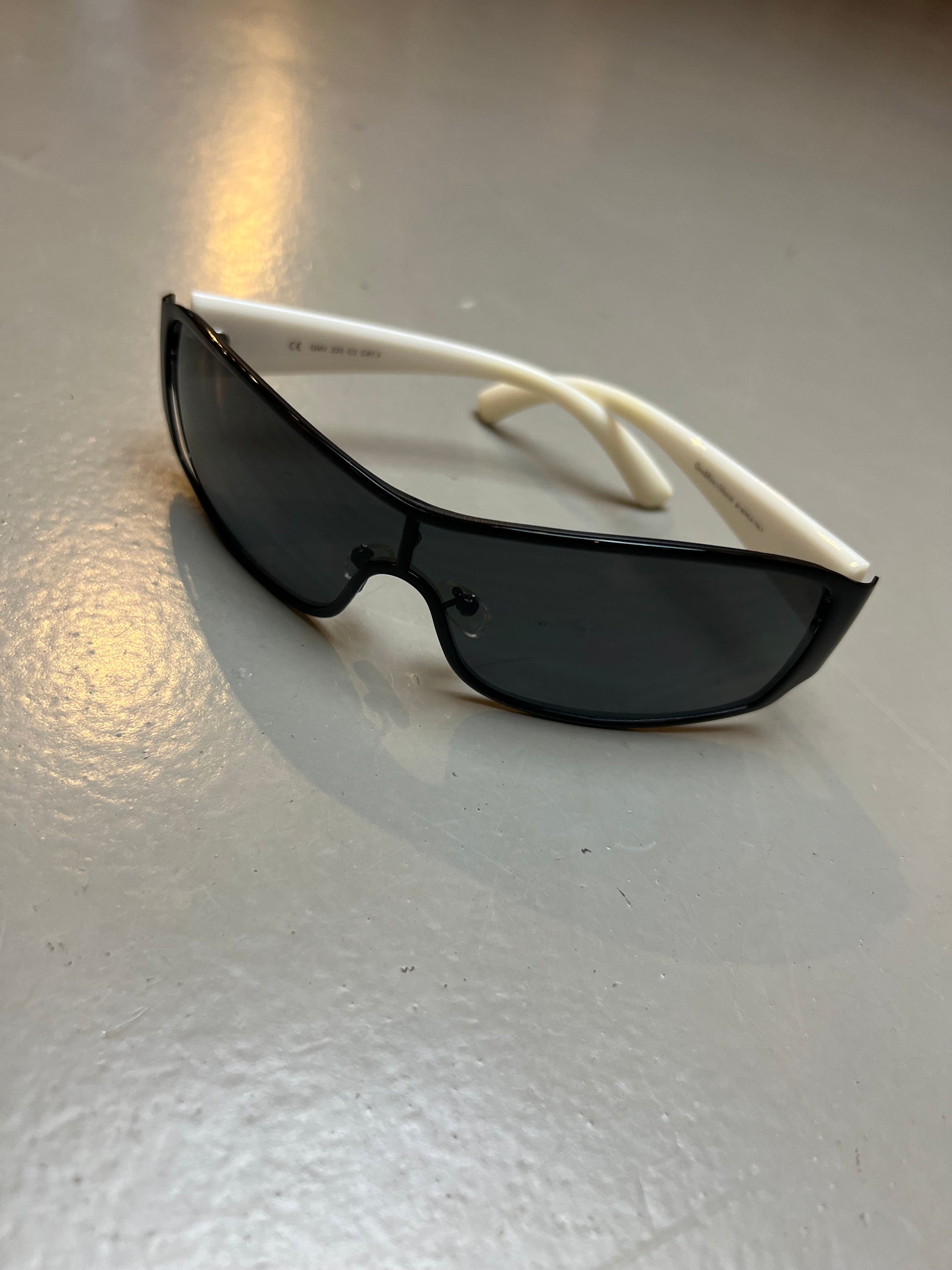 Bild einer Gian Marco Venturi Sonnenbrille mit schwarzen Gläsern und weißem Gestell Von vorne