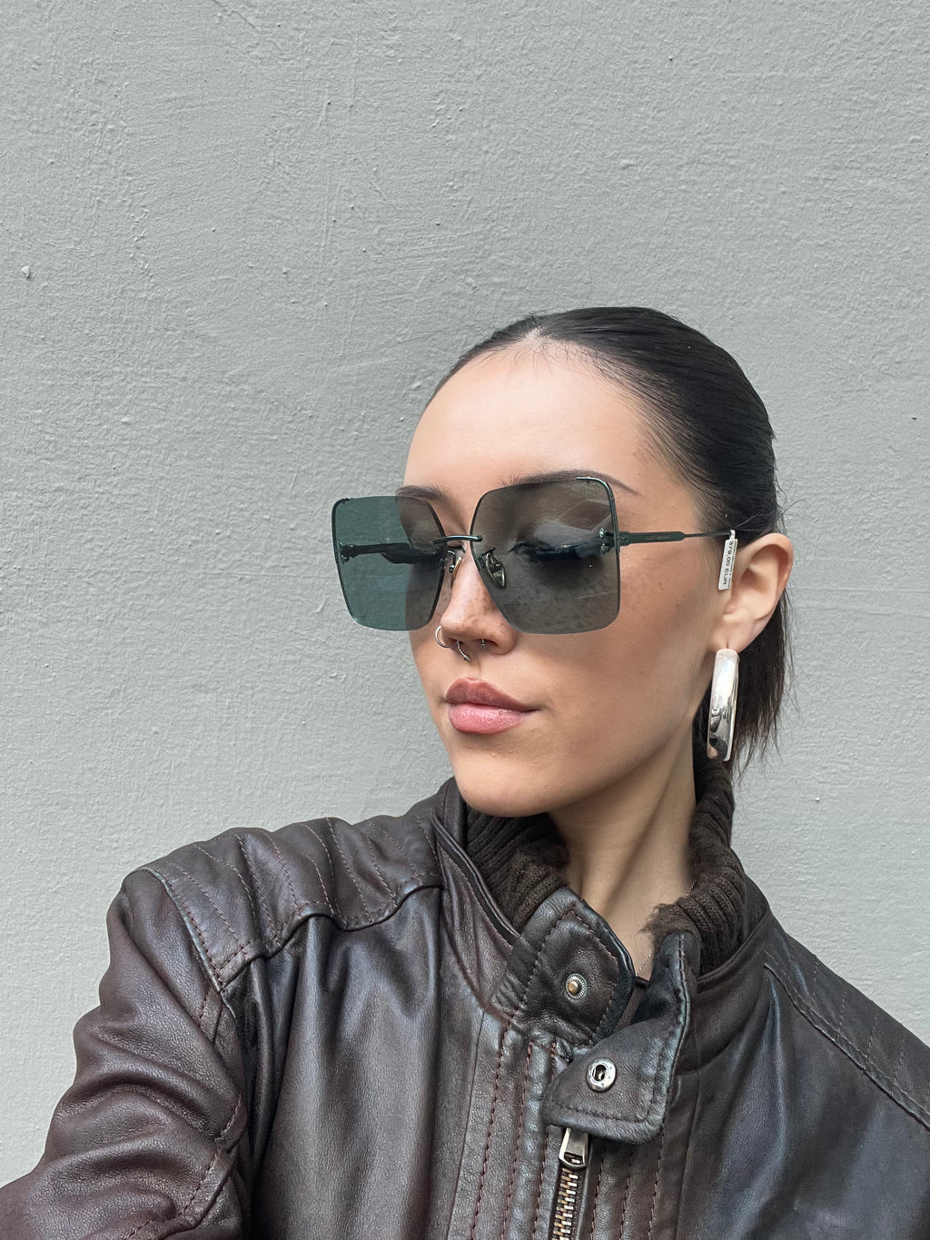 Tragebild der Isabel Marant Dark Green Sunglasses an einem Weiblichemmodel vor grauem Hintergrund.