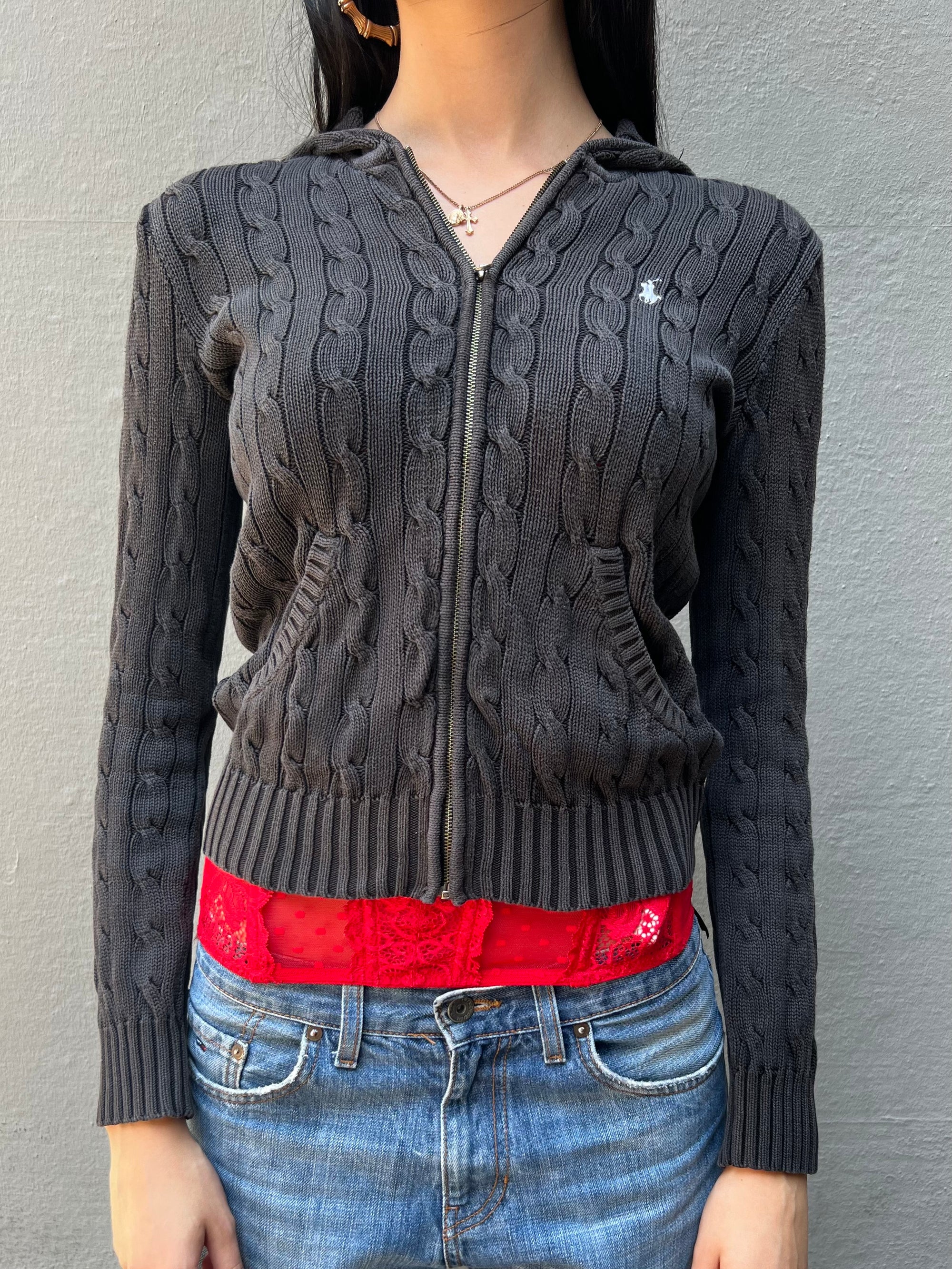 Eine graue Strickjacke von Ralph Lauren mit weißem Reiter Logo auf der Brust in S