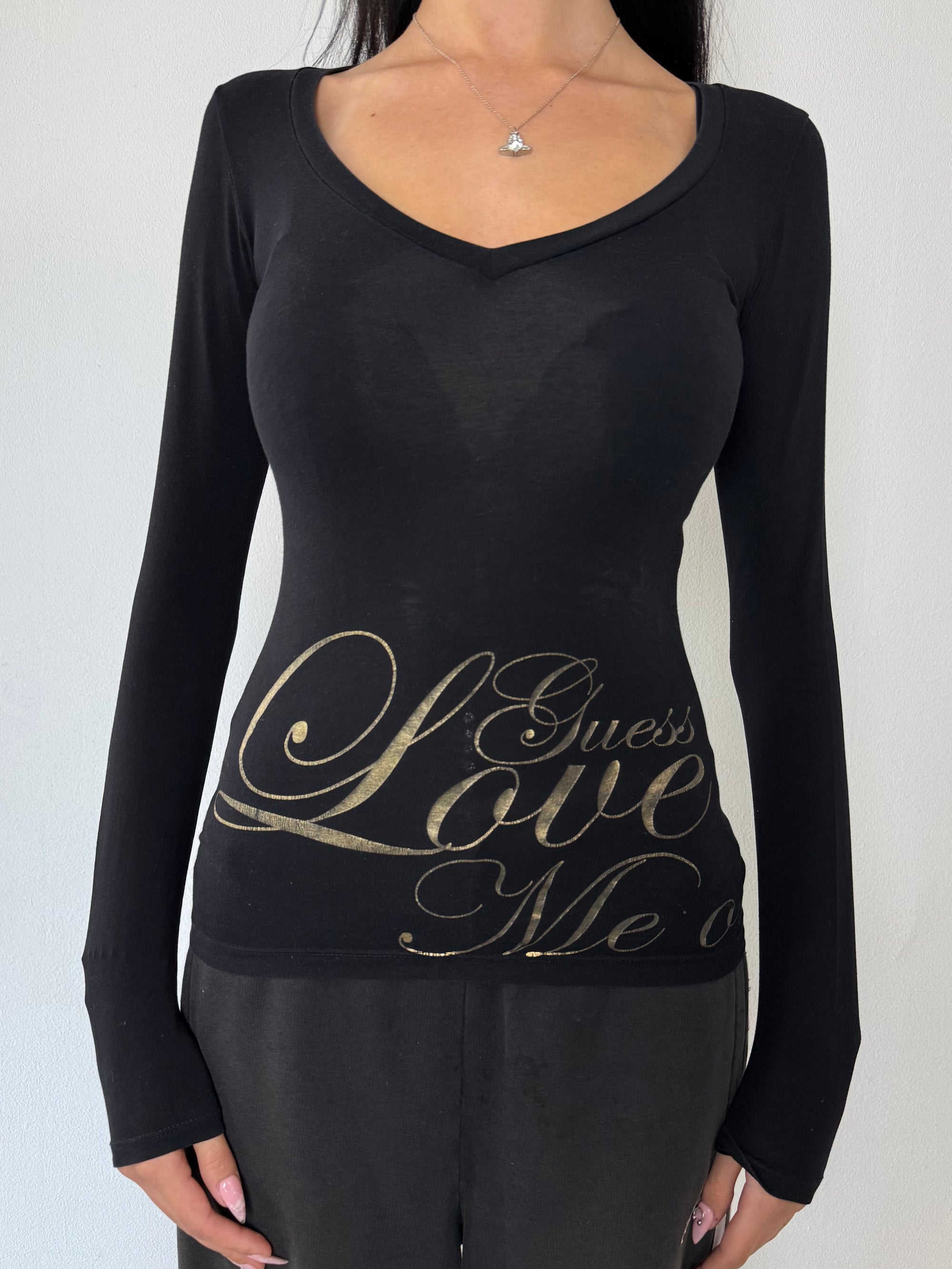 Ein schwarzes Longsleeve von Guess mit goldenem Schriftzug auf der Vorderseite und Rückseite Slim Fit