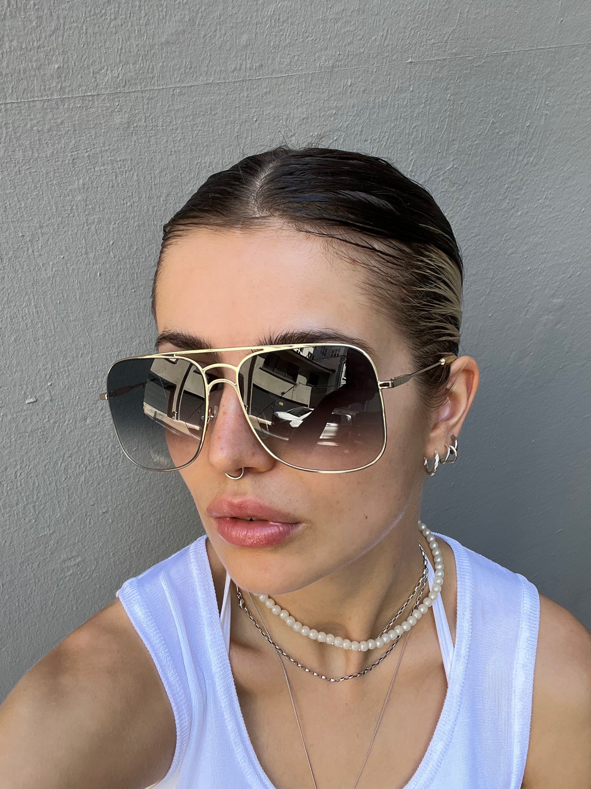 Auf dem Bild ist ein Tragebild der Chloè Sunglasses in Gold von vorne vor grauem Hintergrund zu sehen.