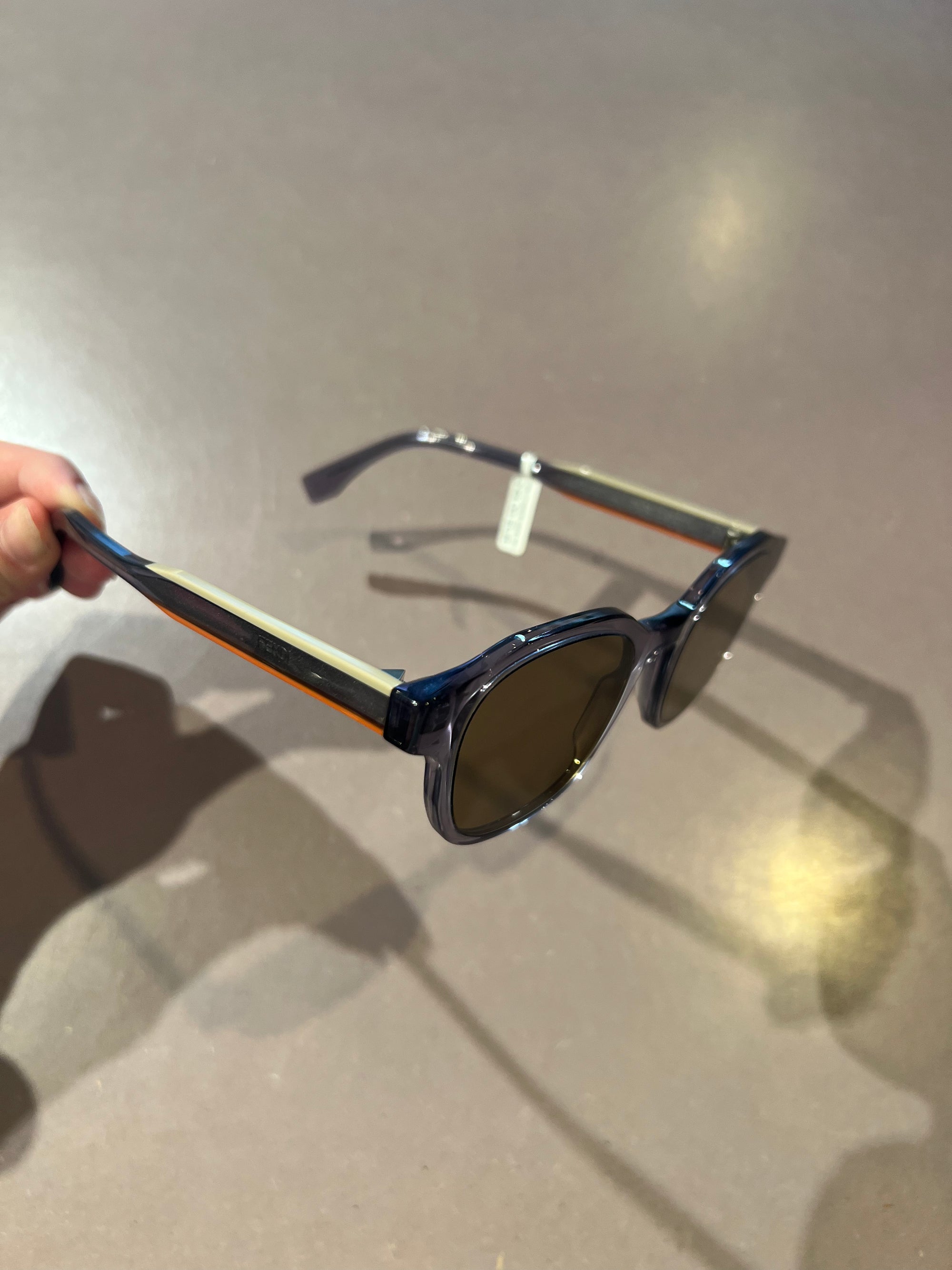 Auf dem Bild ist ein Produktbild der Fendi Roma Sonnenbrille von der Seite vor Grauen Hintergrund zu sehen.