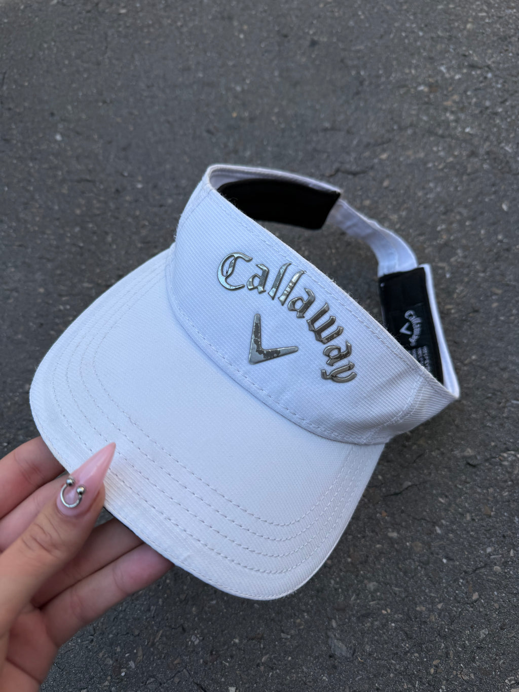 Eine weiße Tennis Cap von Callaway mit dem Logo in Silber vorne und verstellbarem Verschluss 