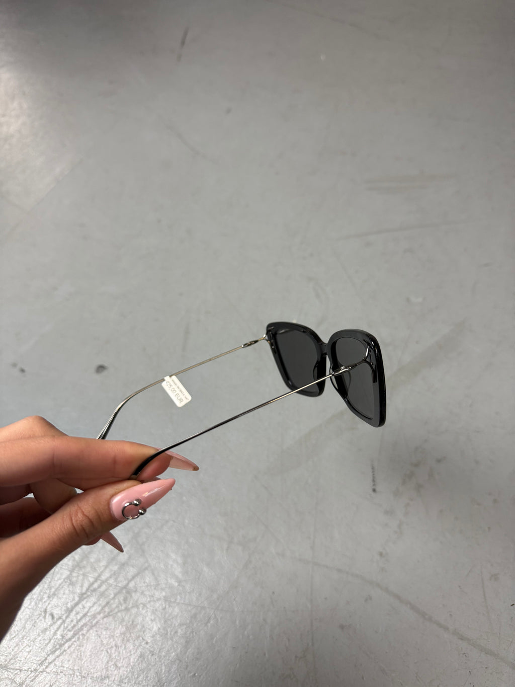 Eine schwarze Sonnenbrille von Dior mit dünnen Bügeln und die Gläser im cateye look 