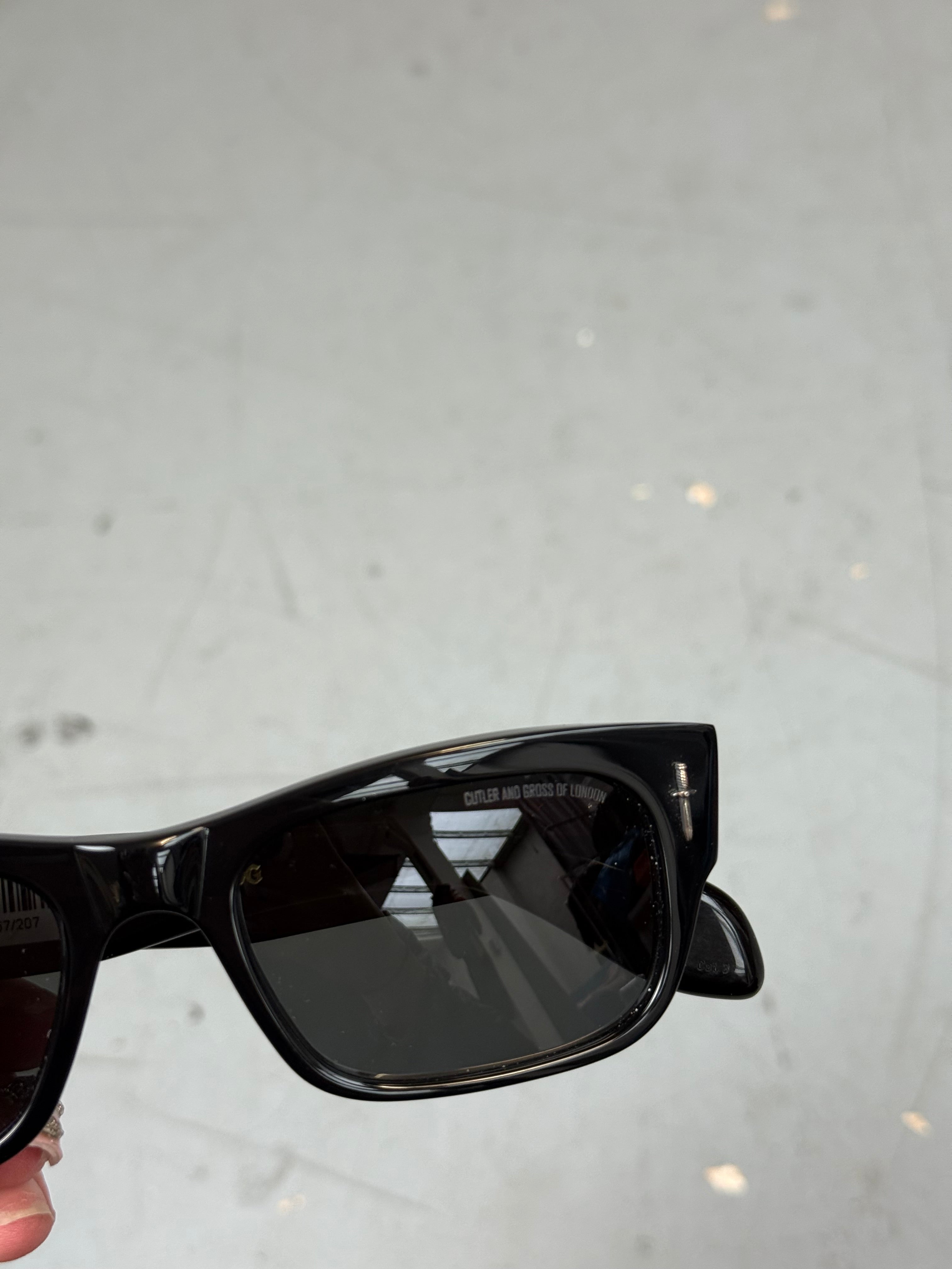 Schwarze Sonnenbrille von cutler & gross mit kleinen Dolch Details am Gestell 