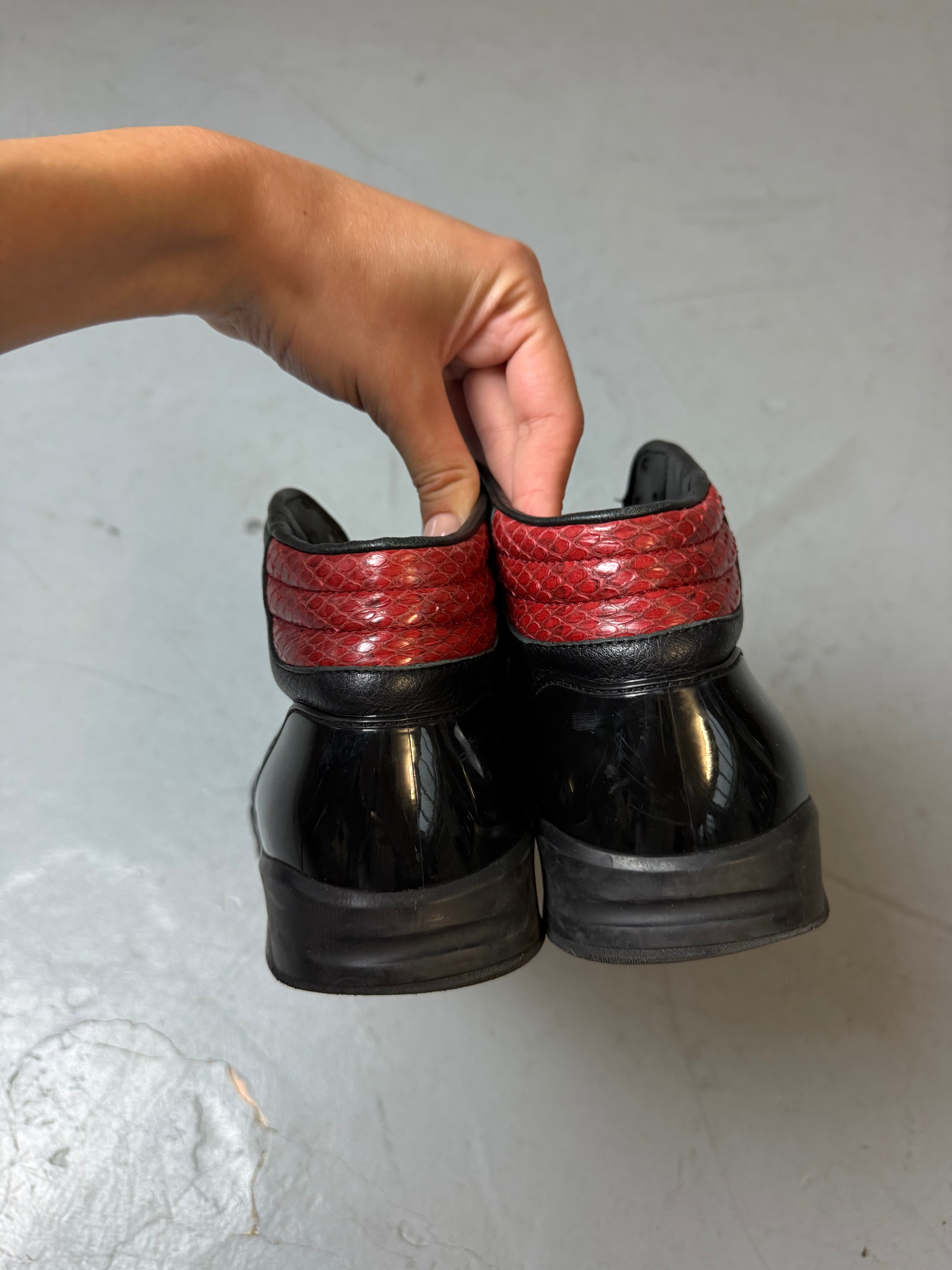 Schwarze gucci sneaker mit roten details hinten und roter sohle 