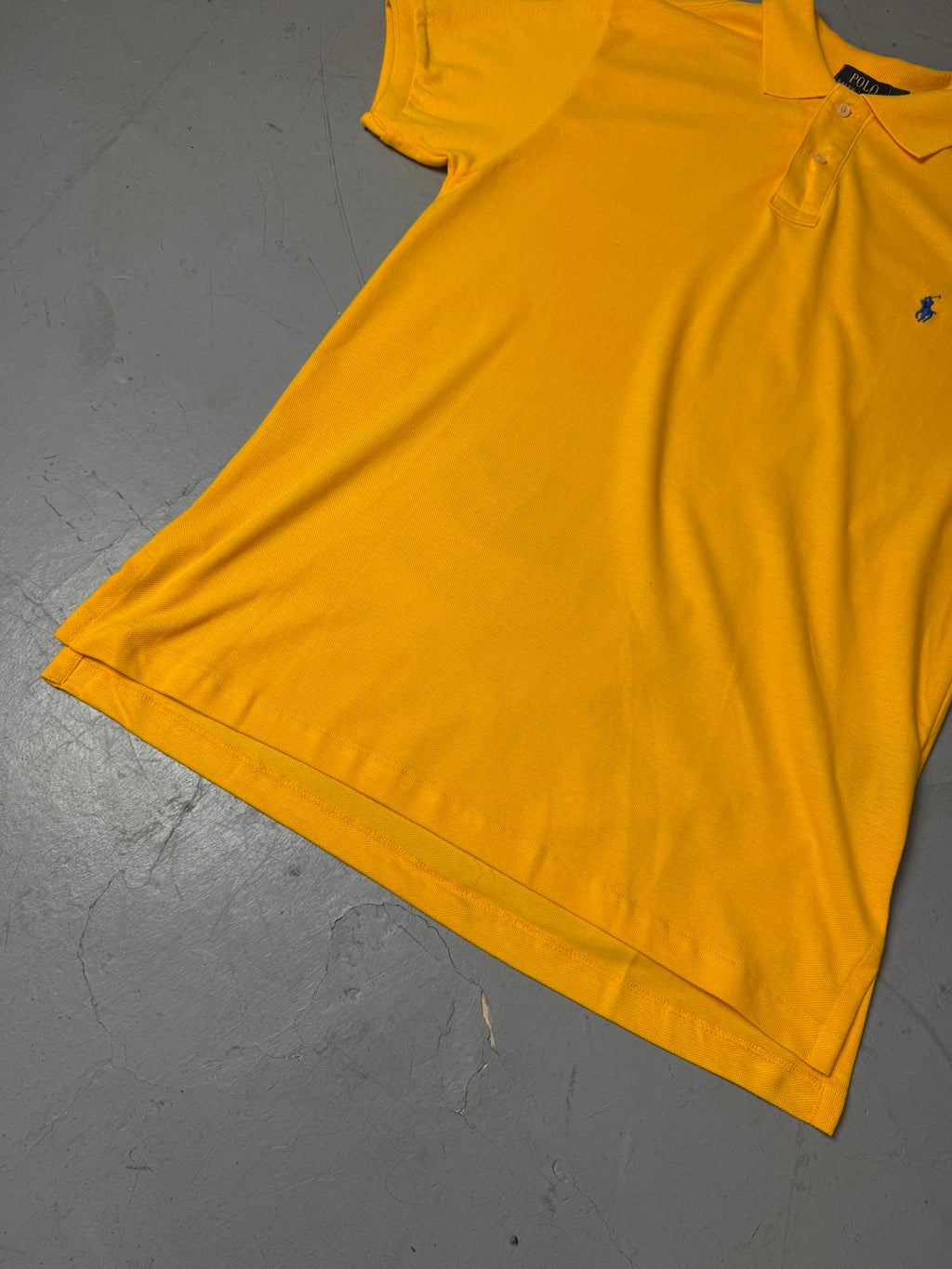 Ein gelbes Polo von Ralph Lauren mit blauem Reiter auf der Brust in L