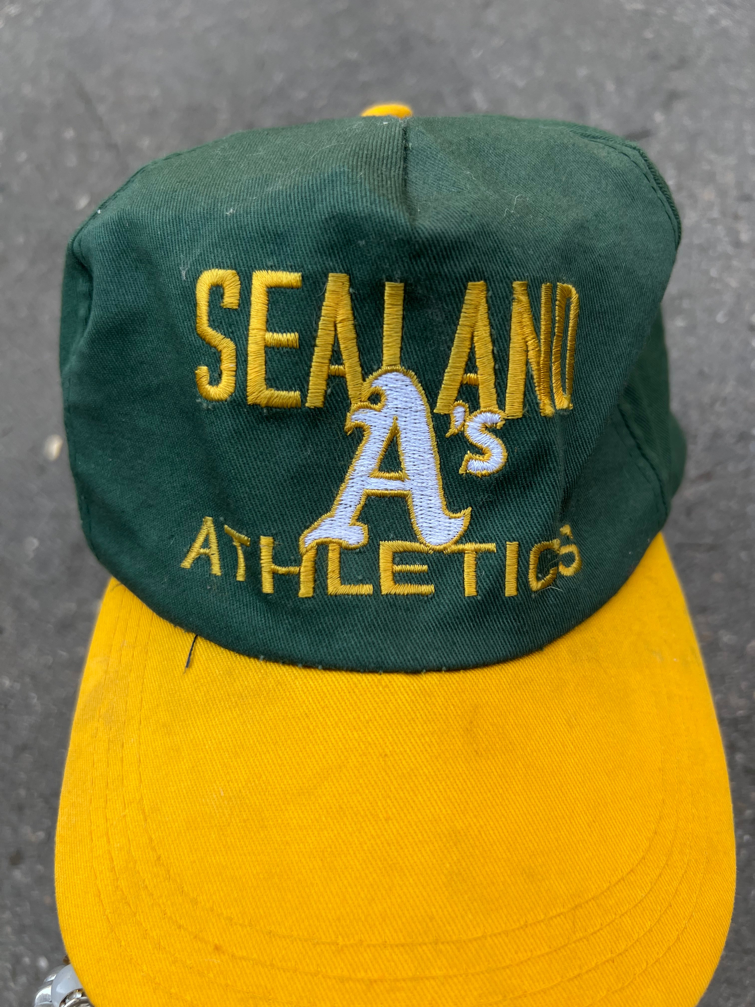 Eine grüne Cap mit gelben Sealand Schriftzug und gelben Schirm