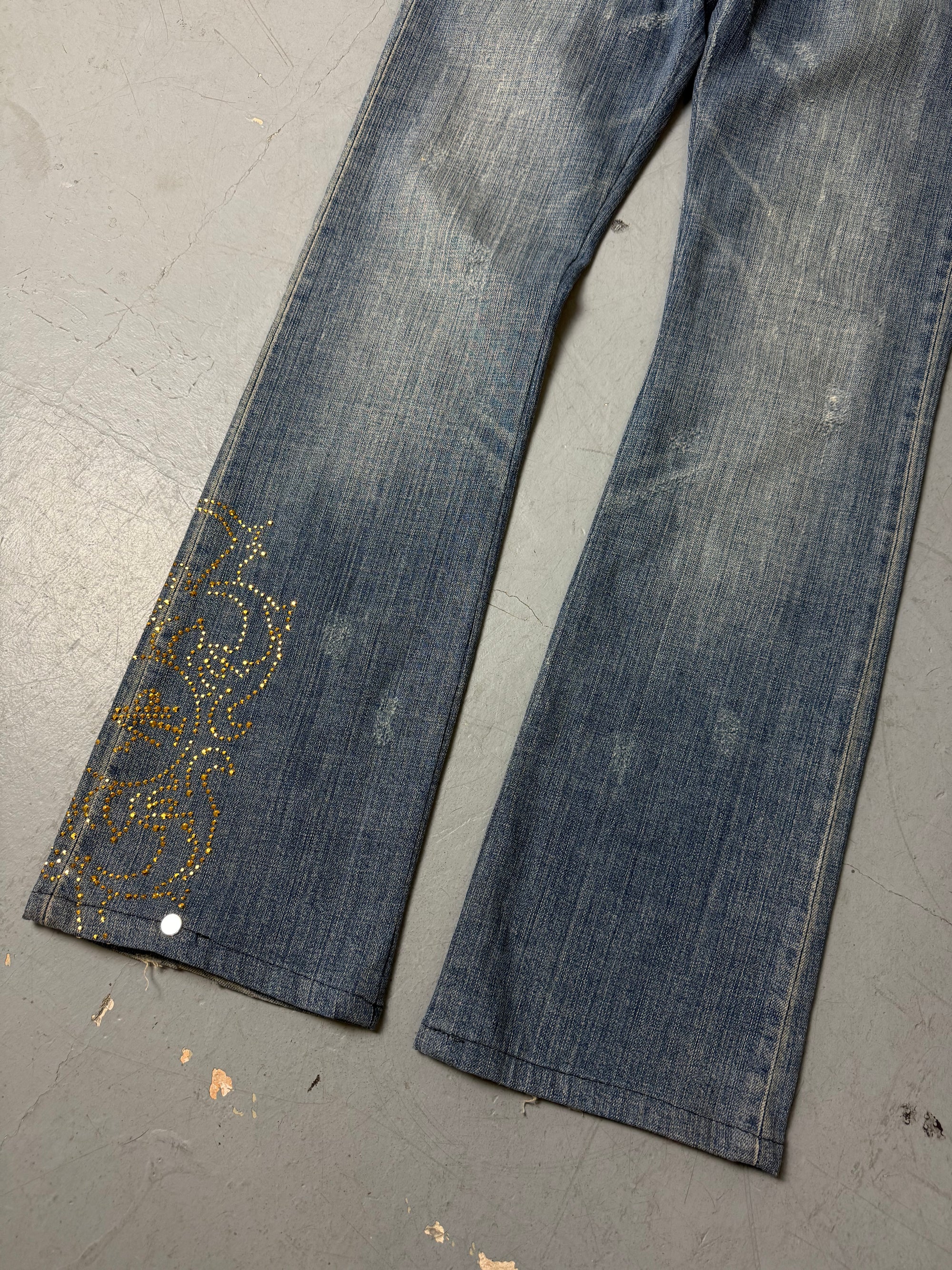 Eine low waist blue washed Versace Jeans im Bootcut Schnitt mit goldenen rhinestones um den Bund und am Bein 