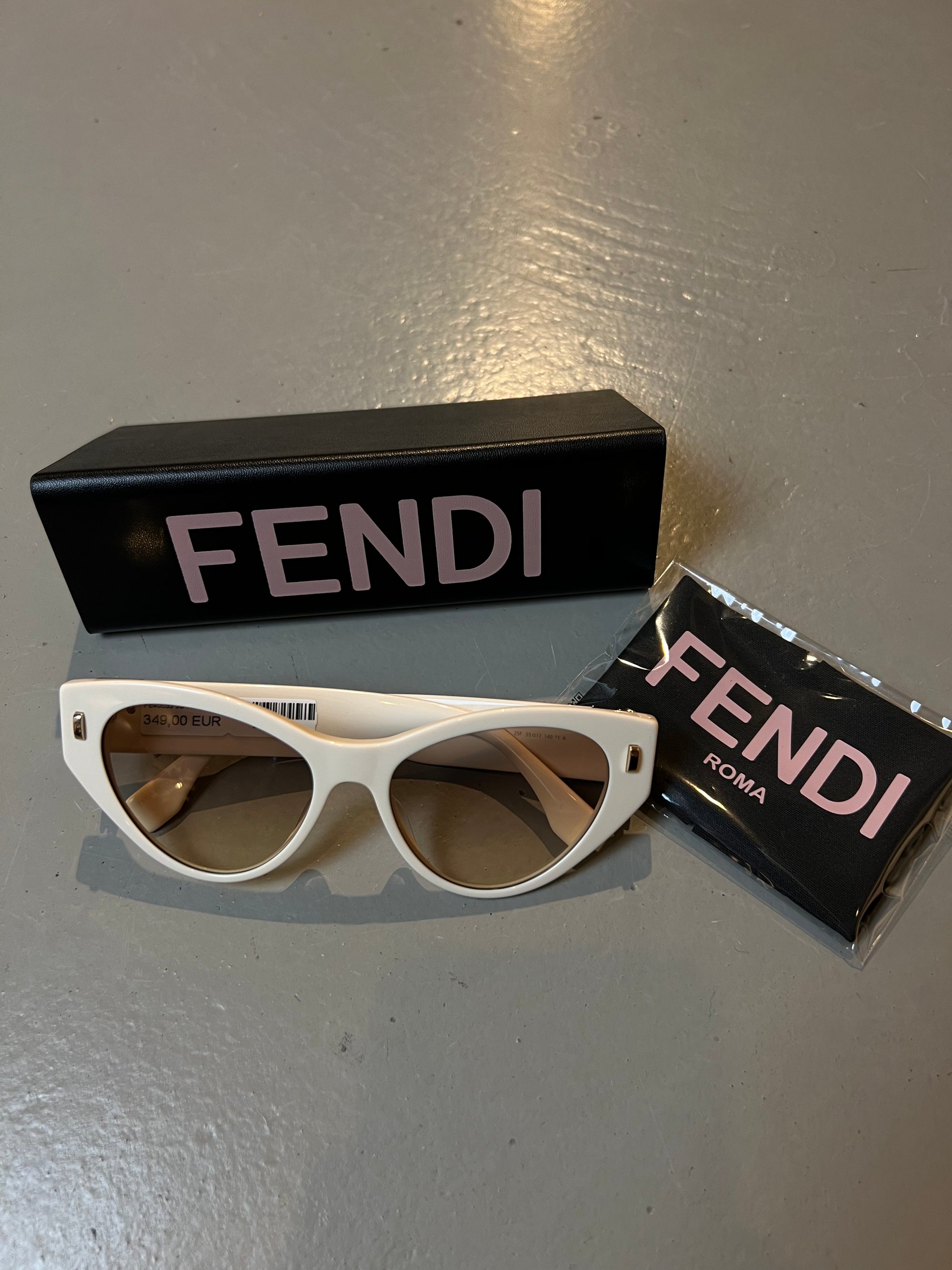 Produktbild der Fendi Beige Cateye Sunglasses von vorne mit Case vor grauem Hintergrund.