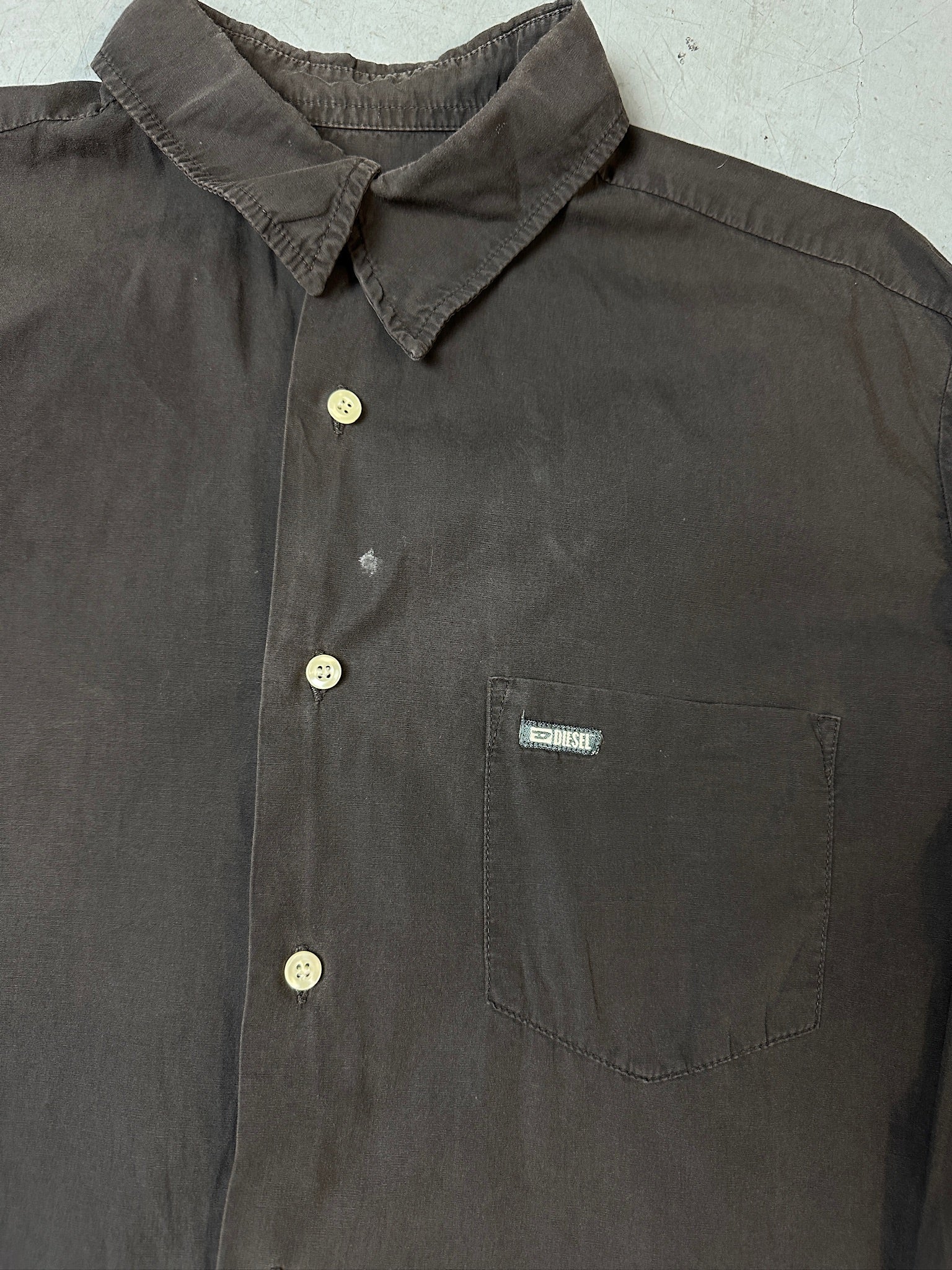 Detailliertes produktbild von grauem Diesel Hemd auf Boden