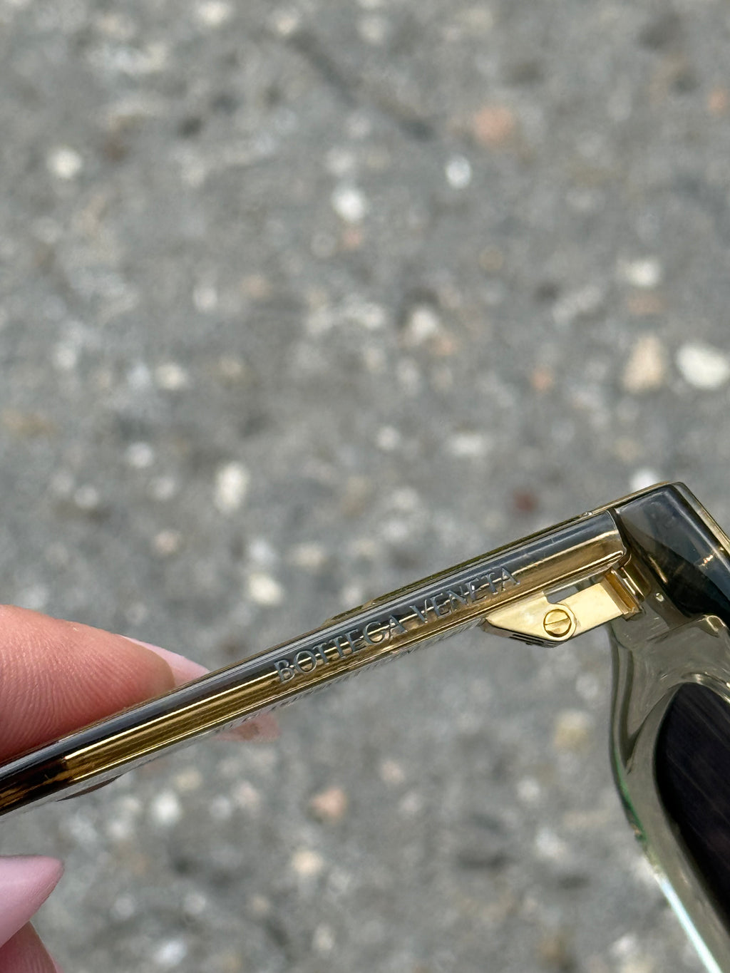 Eine beige transparente Sonnenbrille von Bottega Veneta mit Gold Details