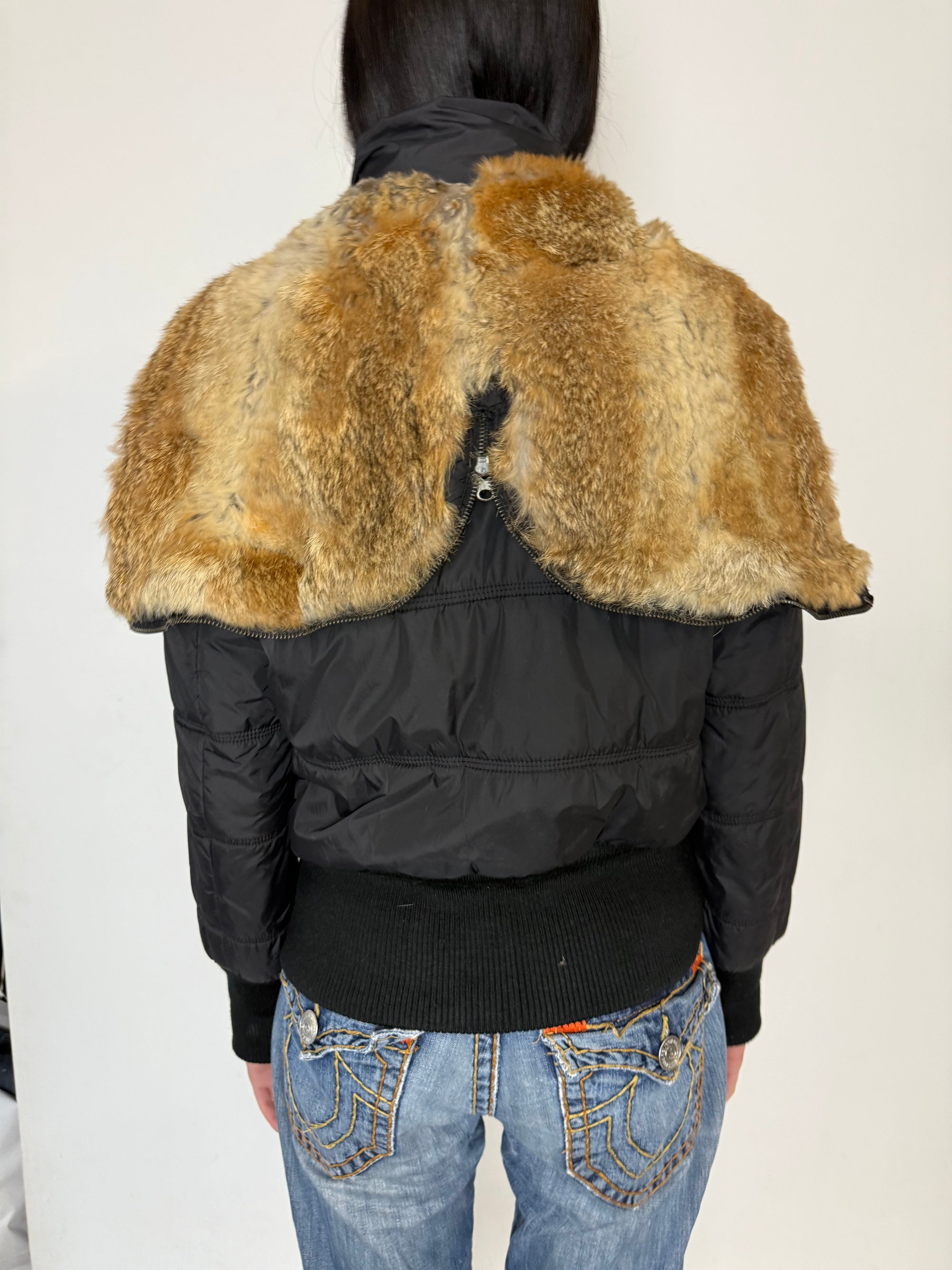 Eine schwarze cropped Puffer Jacke im Y2K Stil mit faux fur Kaputze 