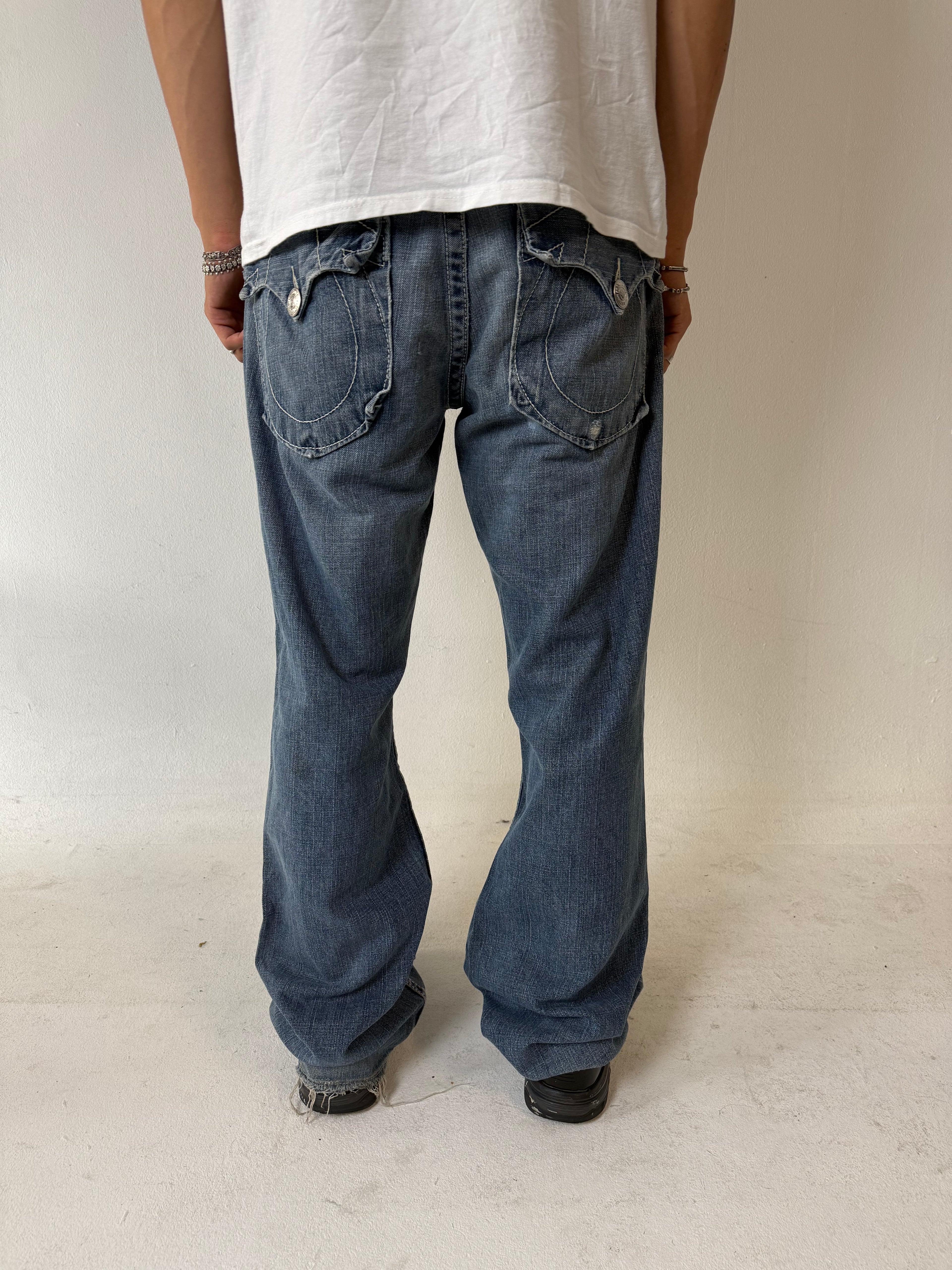 Eine blau-graue baggy True Religion Jeans mit weißen Hufeisen Stitching