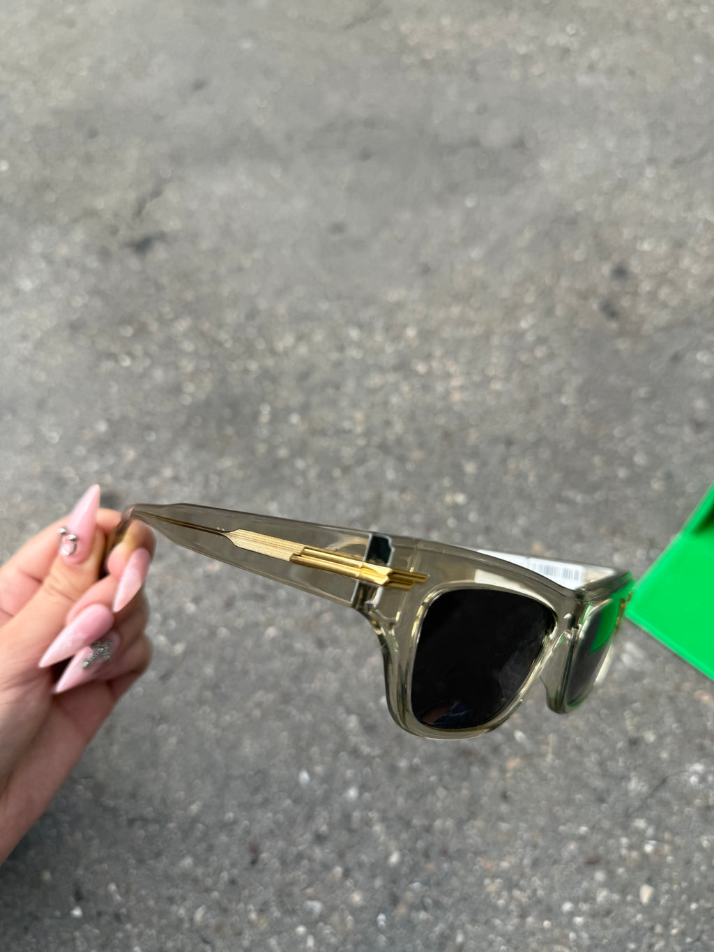 Eine beige transparente Sonnenbrille von Bottega Veneta mit Gold Details