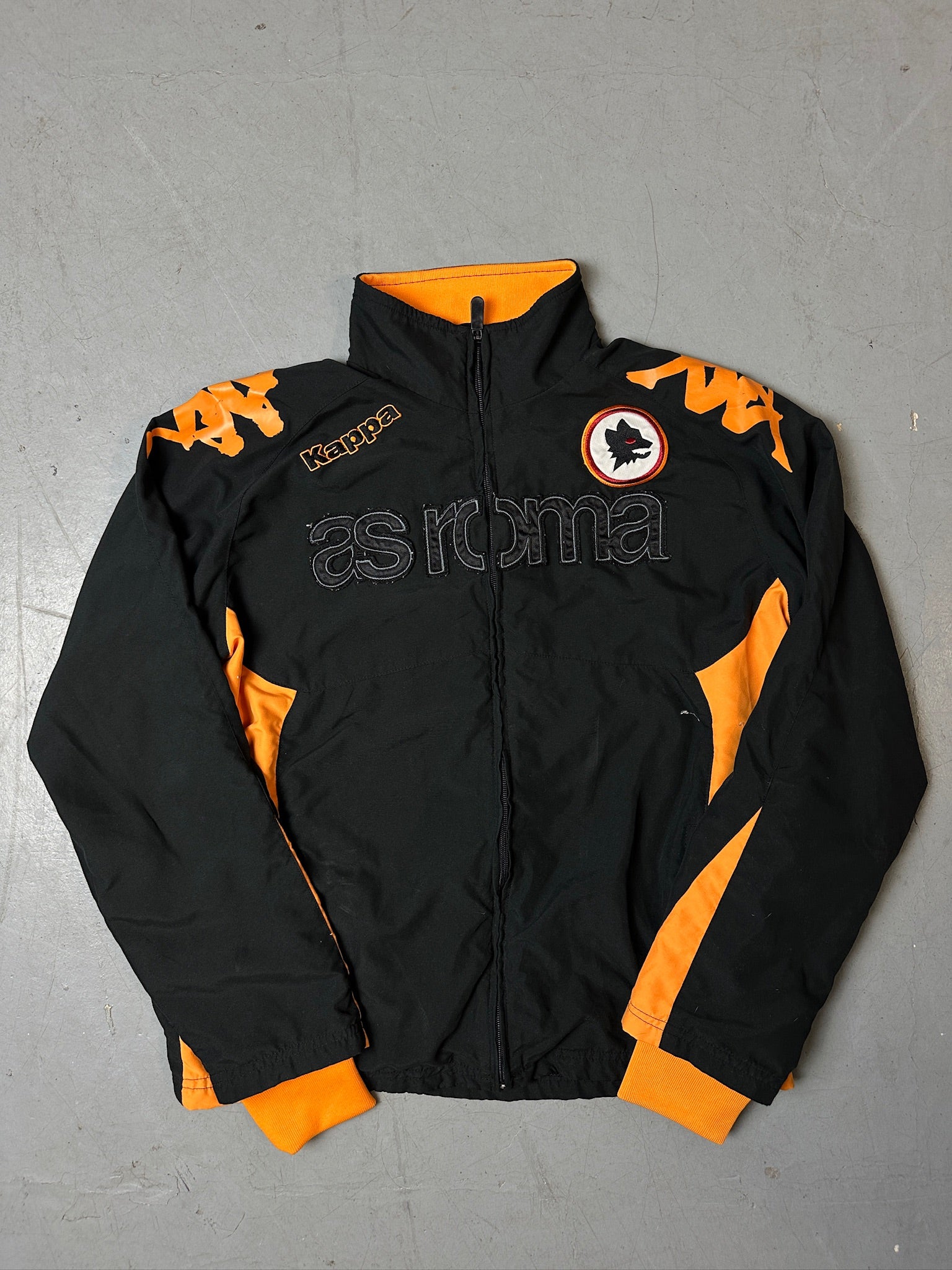Eine schwarz orange Track Jacke von kappa von dem Fußballverein as roma 