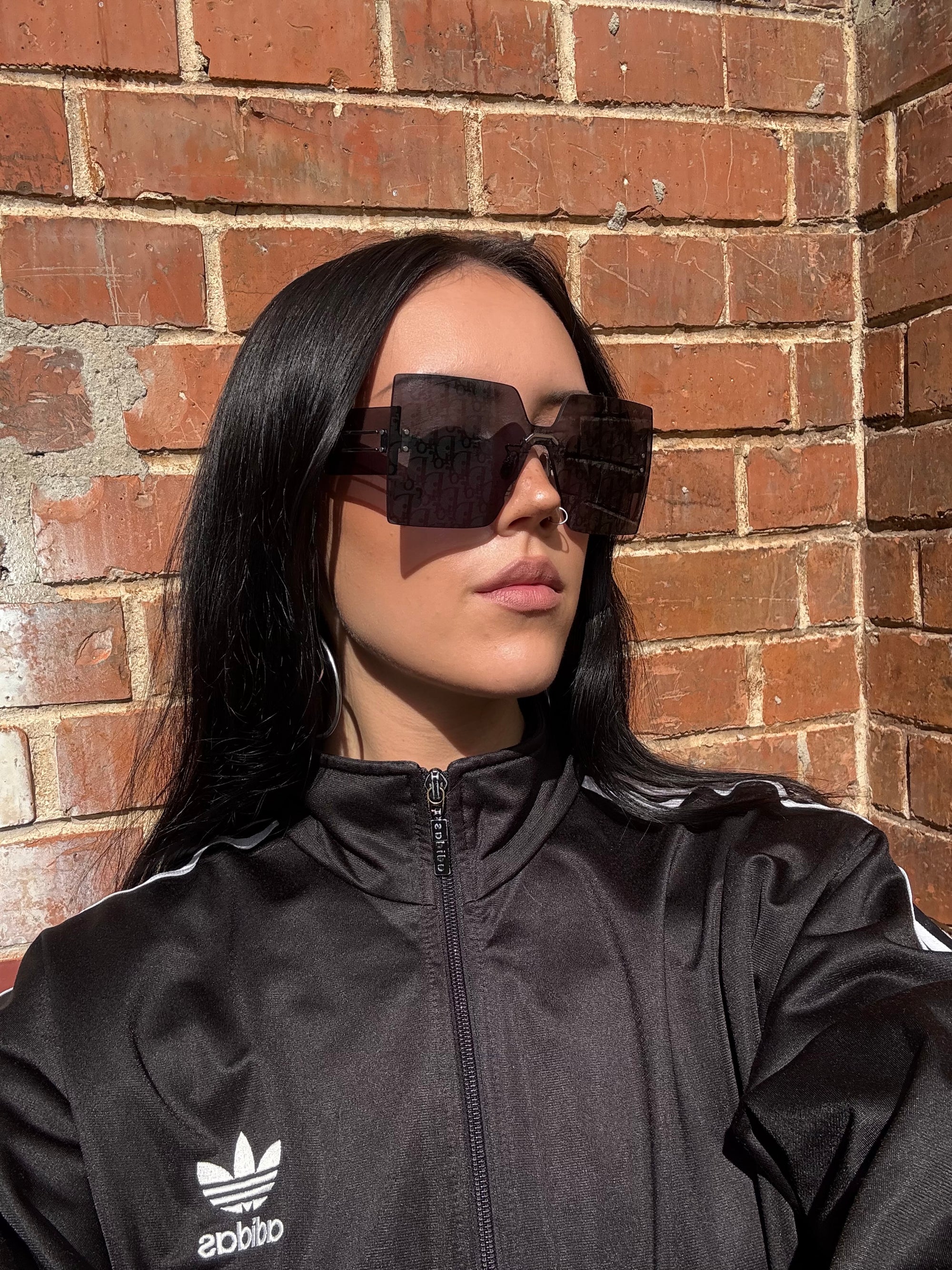 Eine neue Sonnenbrille von dir mit großen eckigen Gläsern mit dem Dior monogram drauf 