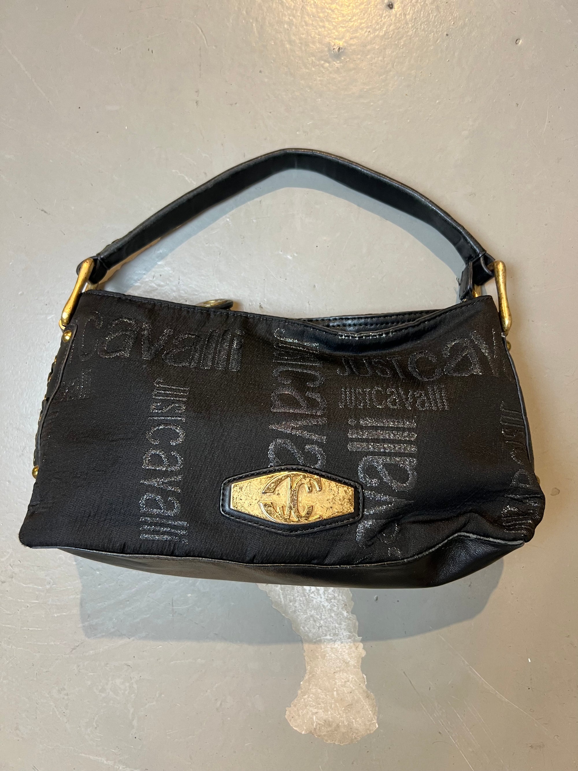 Schwarze schultertasche von just cavalli. Goldene Hardware, Monogramm Muster. Produktbild vor grauem Hintergrund. Frontal.