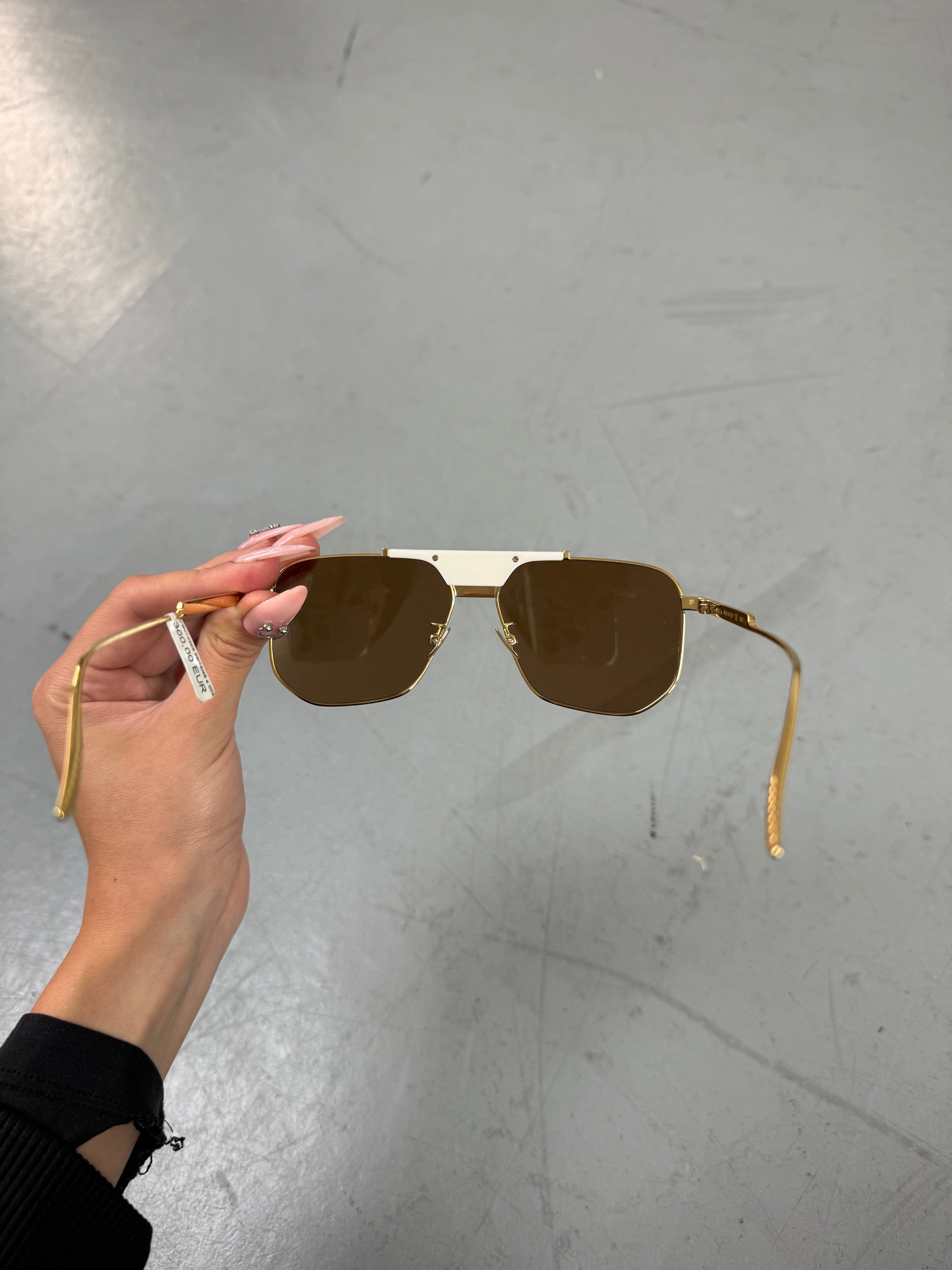 Eine weiß goldene Sonnenbrille mit großen Gläsern von Bottega veneta 