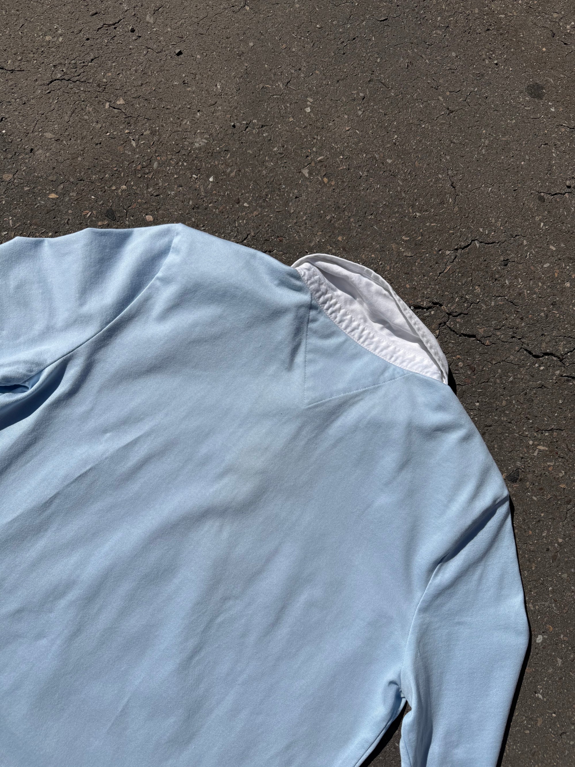 Ein babyblaues langärmliges Polo mit weißem Kragen und Hilfiger in Silber auf der Brust geschrieben 