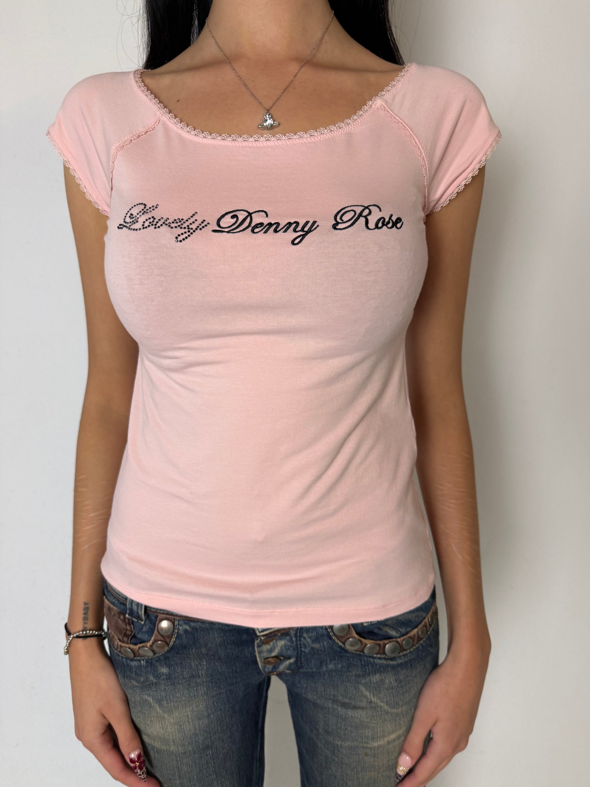Ein rosa tshirt von Denny Rose mit schwarzem Logo auf der Brust und lace am Kragen und den Ärmeln 