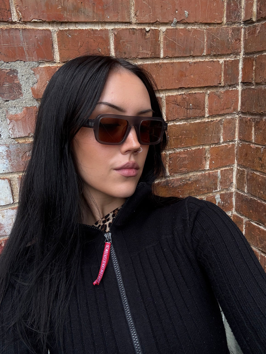 Eine rechteckige Sonnenbrille mit orangen Gläsern und grauem Gestell von Loewe 