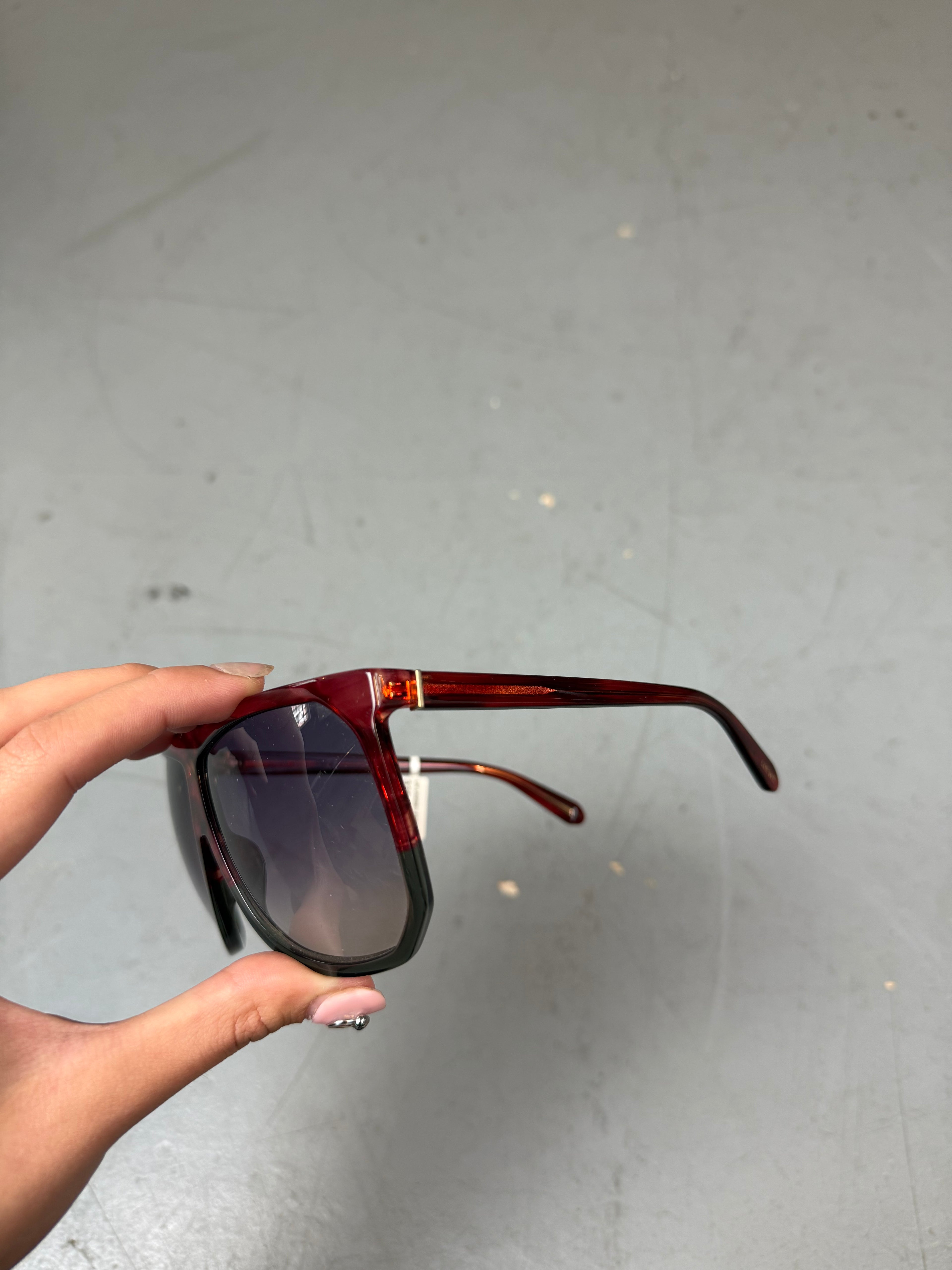 Eine Loewe Sonnenbrille mit großen dunklen Gläsern und rotem Gestell 