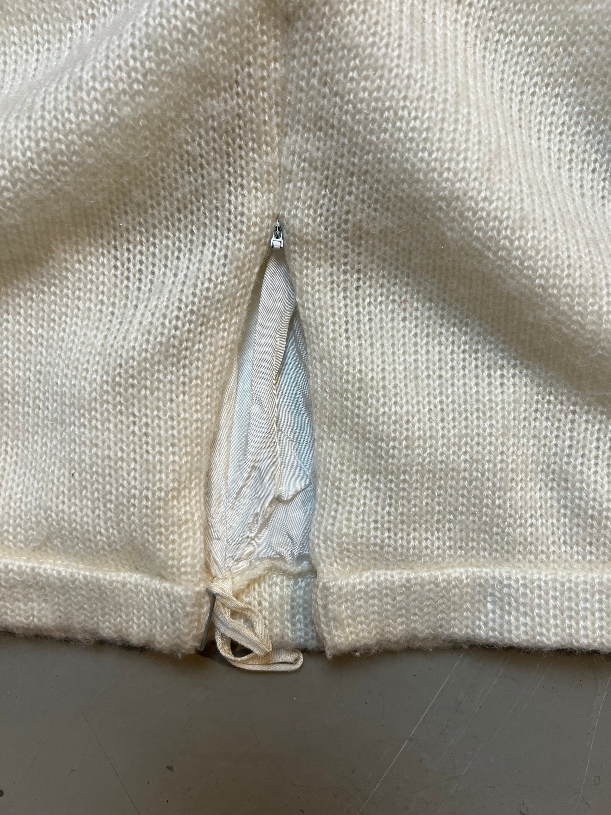 langer Weißer Strickrock, produktbild vor grauem Untergrund, Ansicht den Reißverschluss 