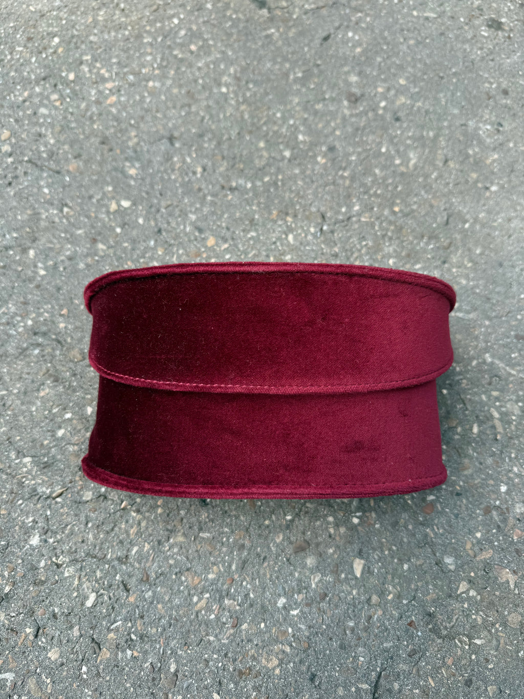 Eine burgunderrote Sonnenbrille von Gucci mit dem Logo in Gold an der Seite und großen quadratischen Gläsern