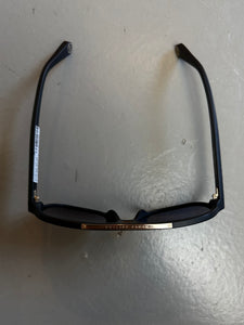 Zu sehen ist ein Produktbild von oben von Philipp Plein Sunglasses vor einem grauen Hintergrund.