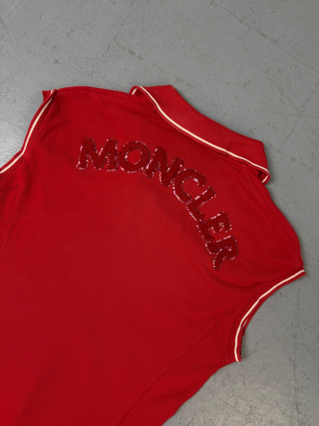 Ein rotes Moncler Polo ärmellos mit Moncler auf dem Rücken 