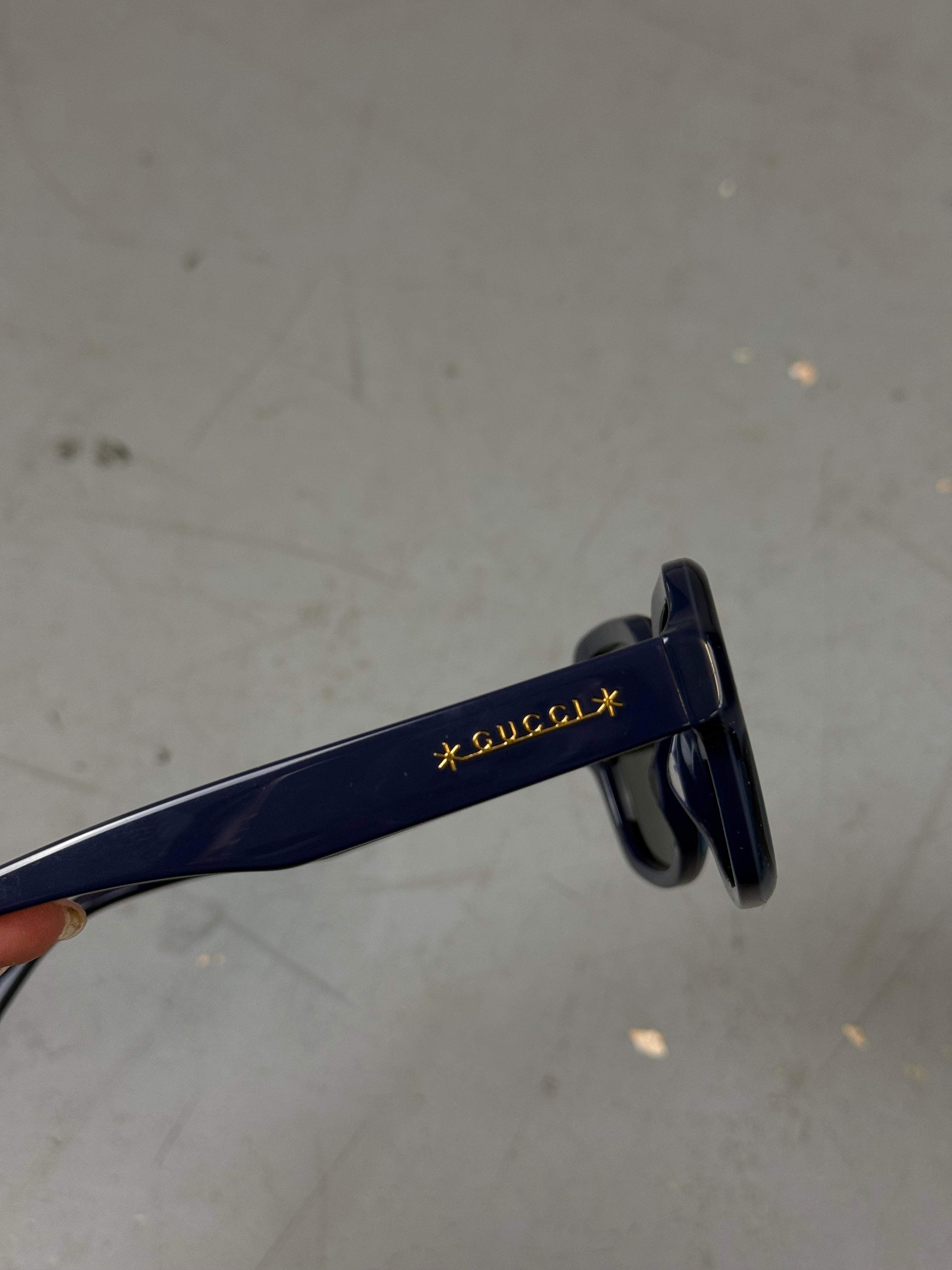 Eine blaue Sonnenbrille von gucci mit großen Gläsern 