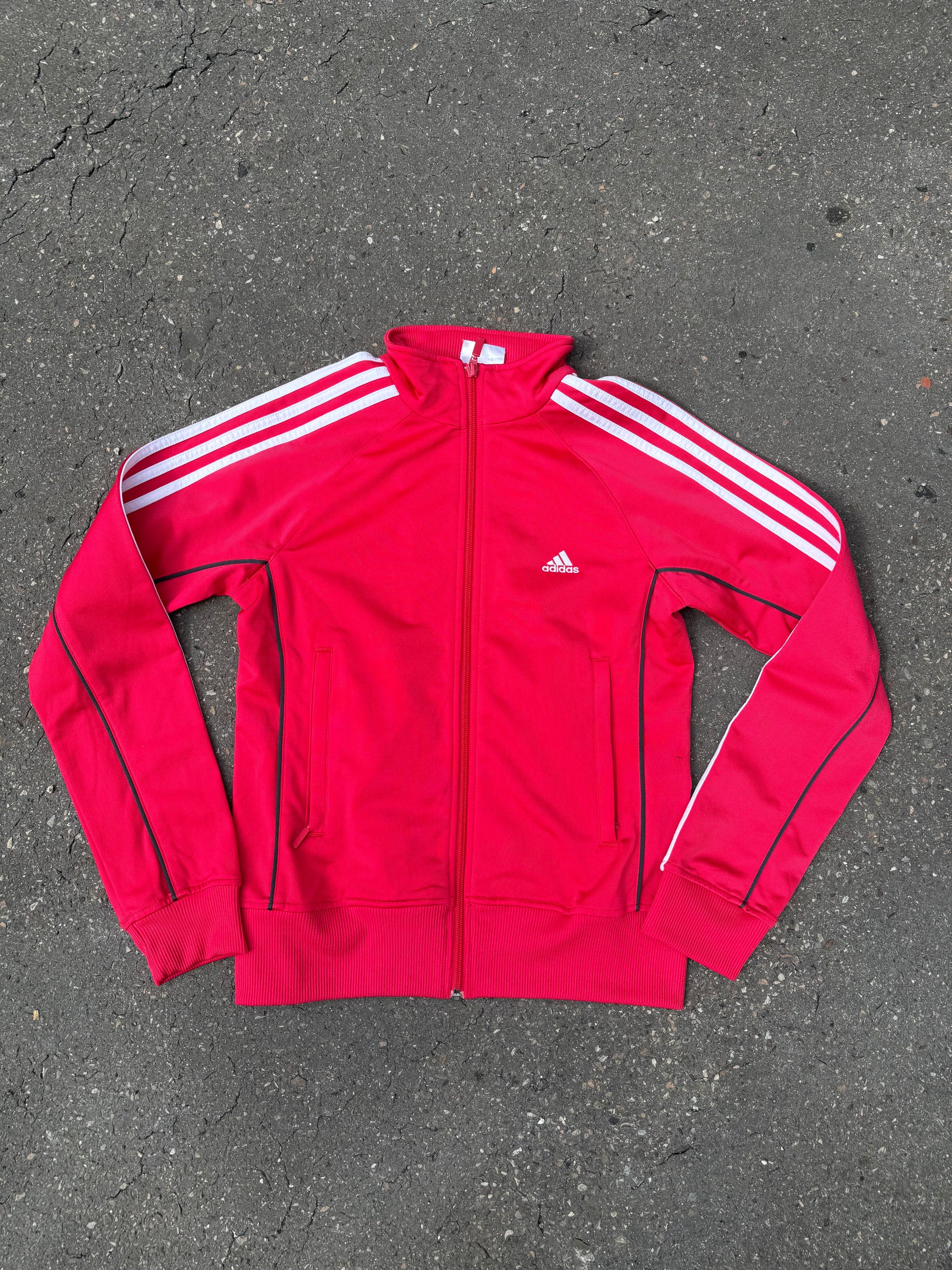 Eine Pinke Trackjacke von Adidas mit weißen Streifen auf den Ärmeln