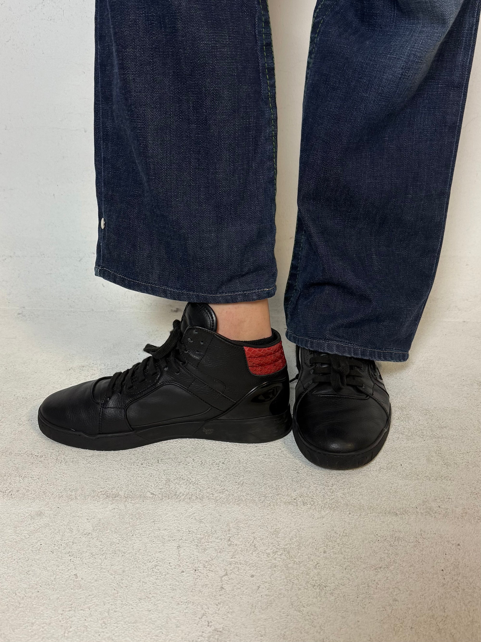 Schwarze gucci sneaker mit roten details hinten und roter sohle