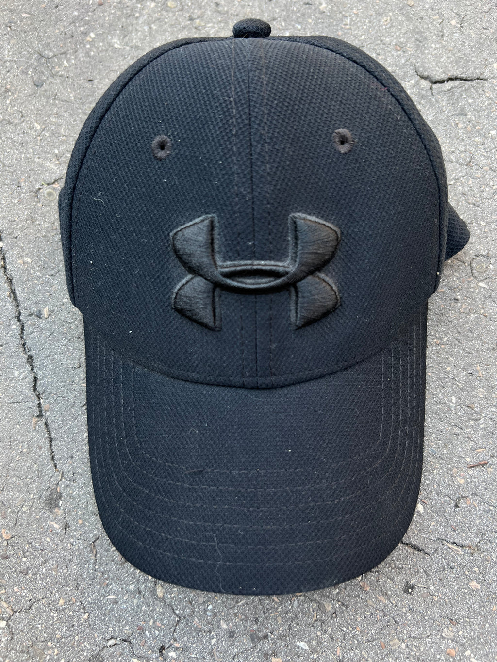 Eine schwarze Under Armour Cap mit dem Logo auf der Vorderseite 