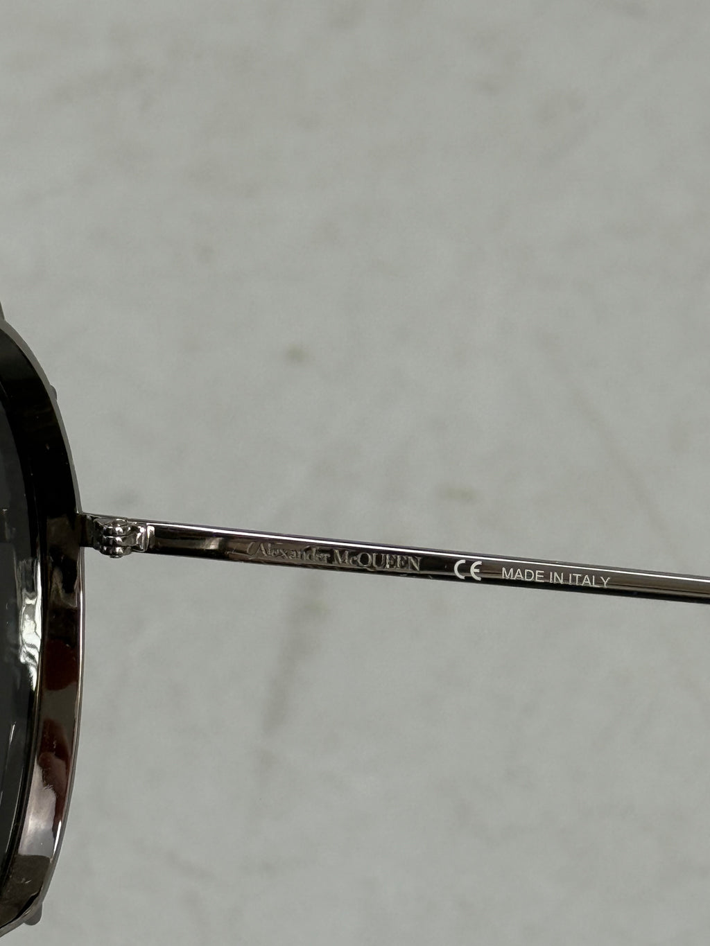 Eine Sonnenbrille von Alexander McQueen mit silbernen Nieten um die großen Gläser und dünnem Gestell 