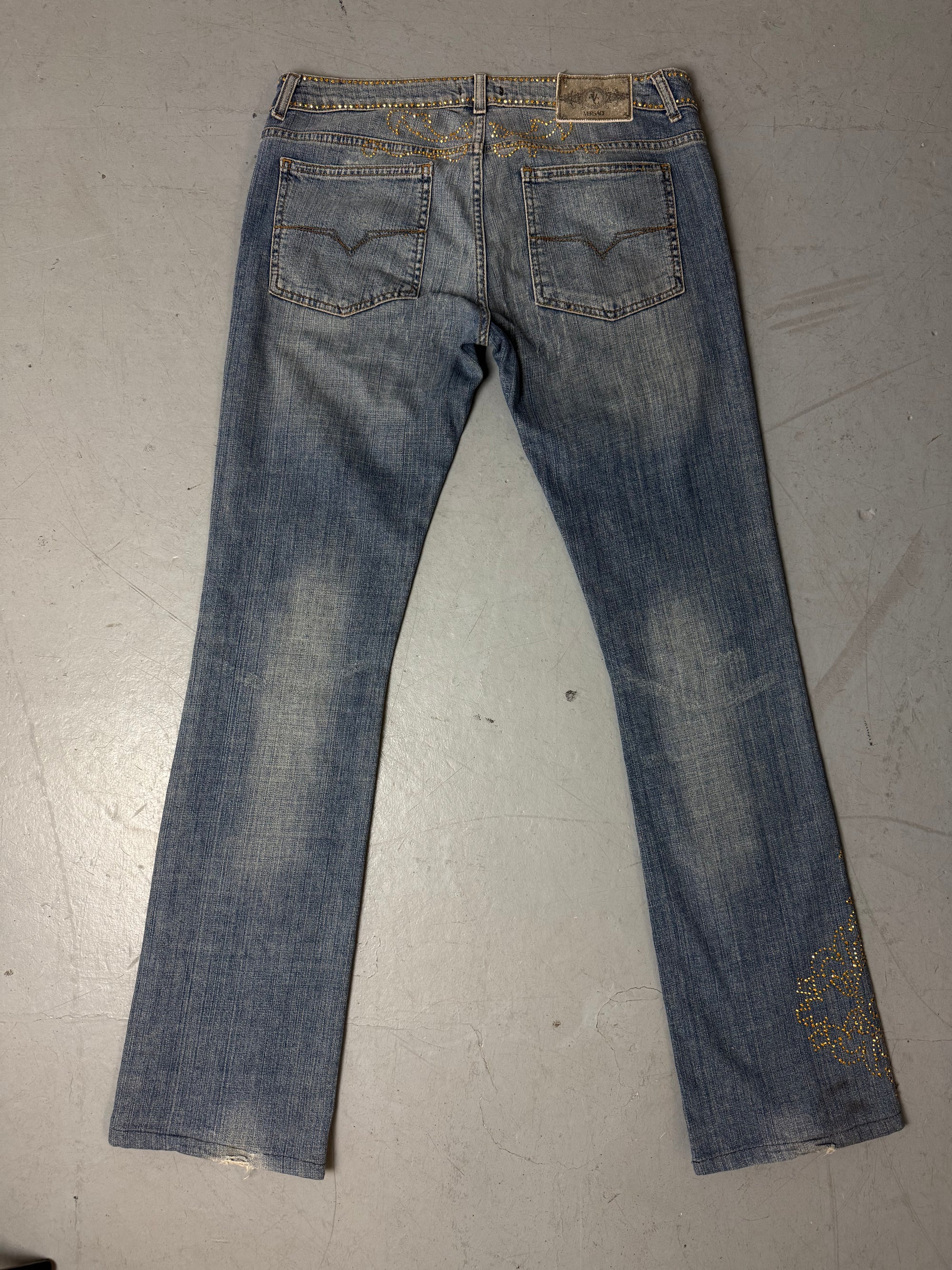 Eine low waist blue washed Versace Jeans im Bootcut Schnitt mit goldenen rhinestones um den Bund und am Bein 