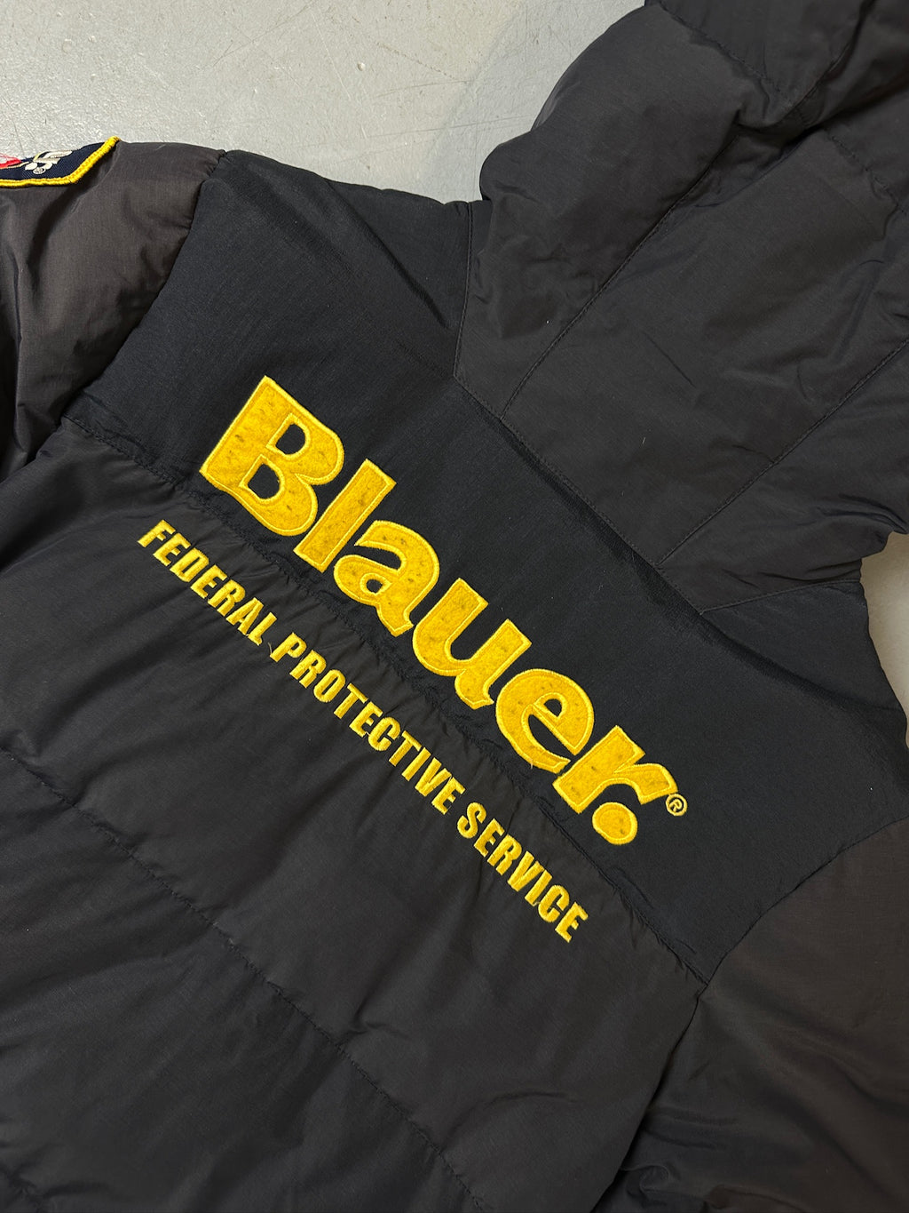 Detailliertes Produktbild von Grauer Blauer Daunen Jacke in L für grauem Boden