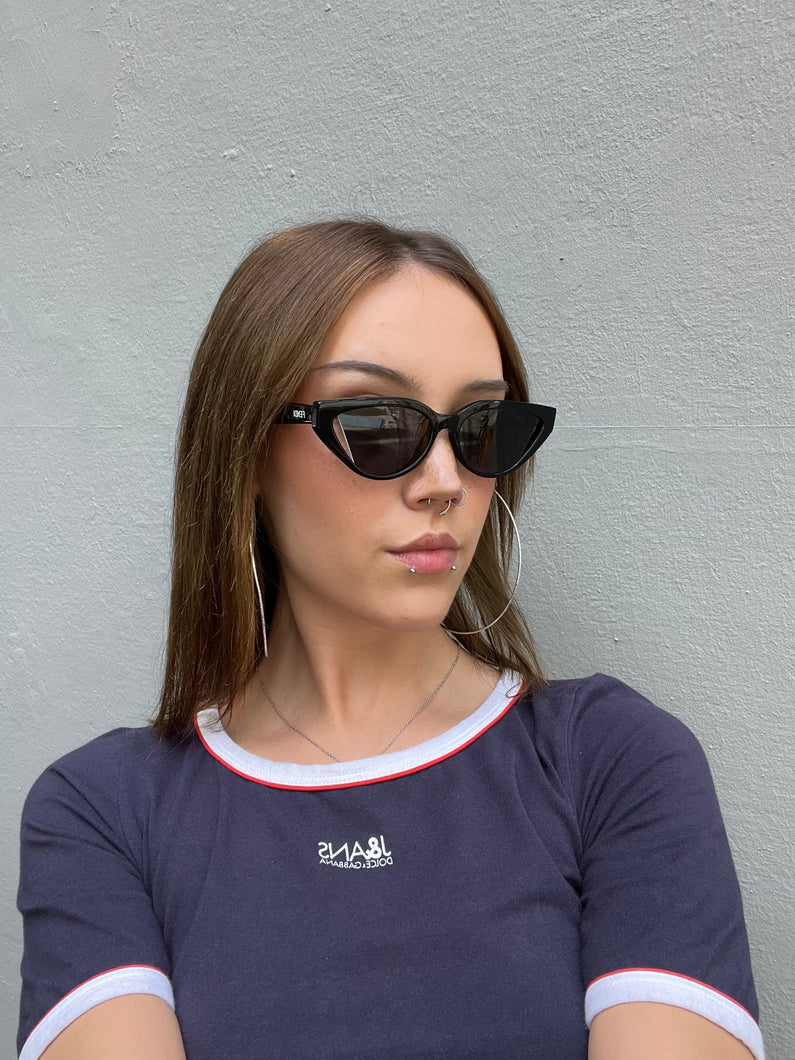 Tragebild von schwarzer Fendi Cat-Eye Sonnenbrille vor grauem Hintergrund.
