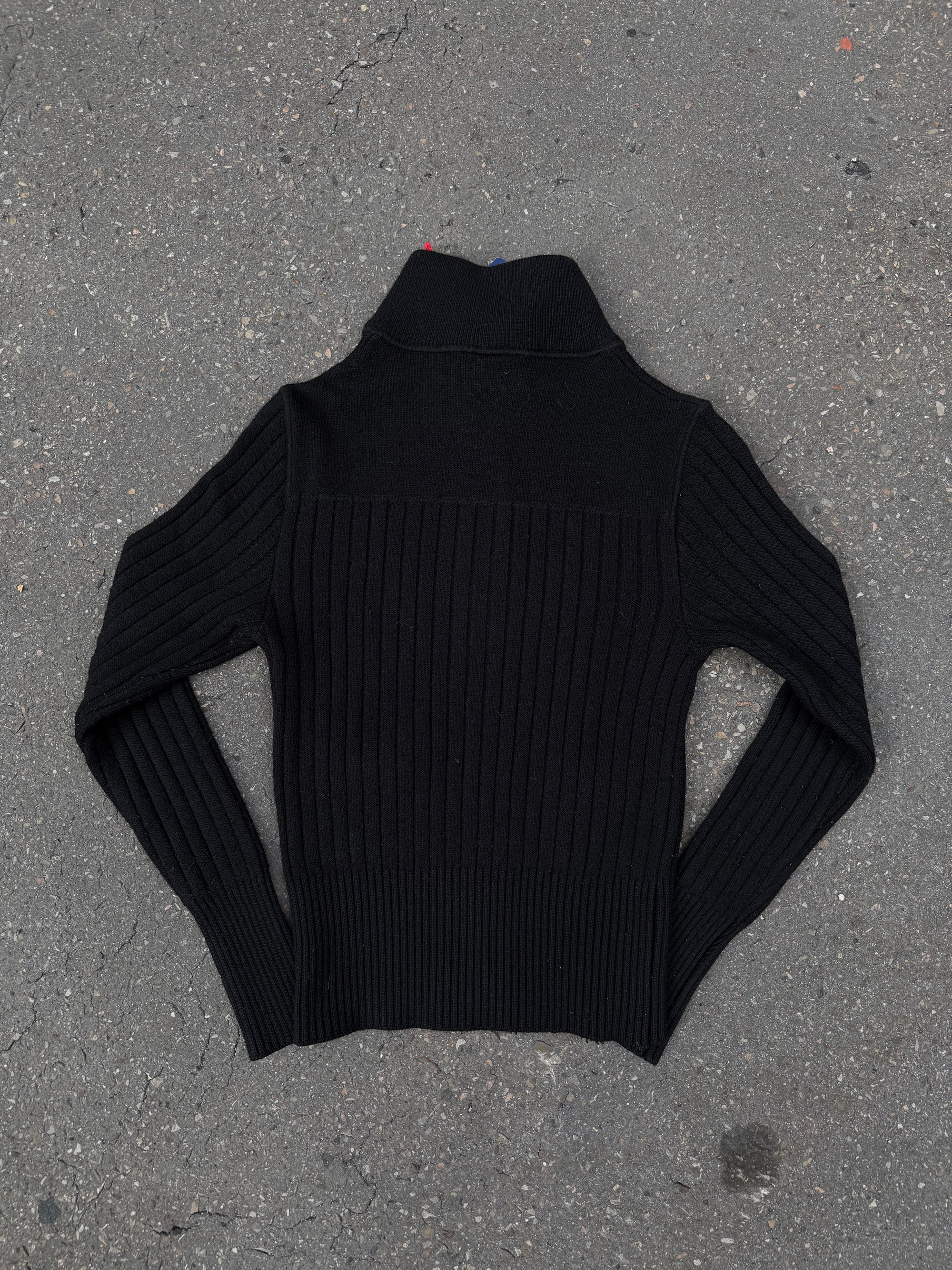 Ein schwarzer Strick Zipper von Dirk Bikkembergs mit roter Schlaufe am Reißverschluss in XS